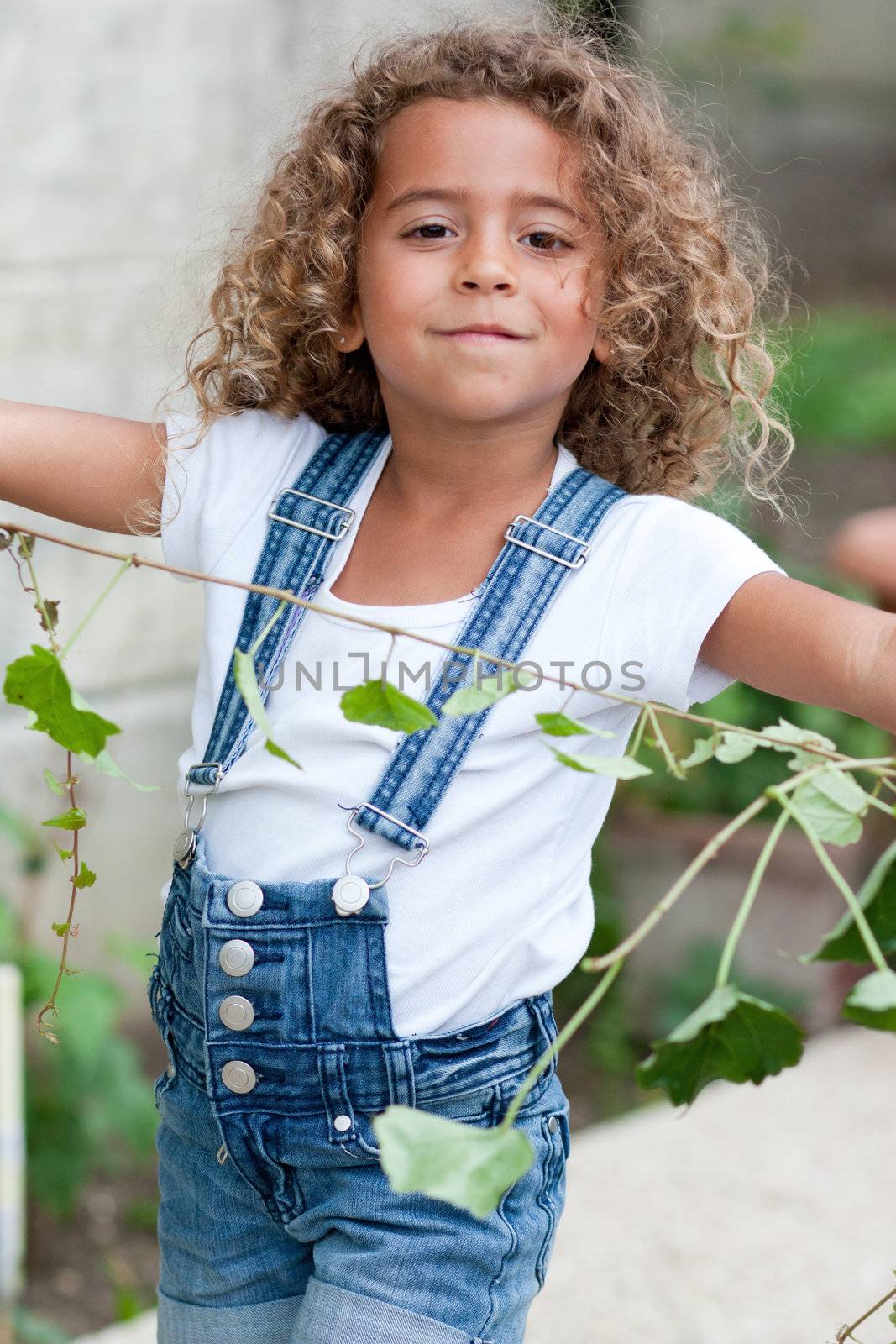 Cute little girl weeding the garden