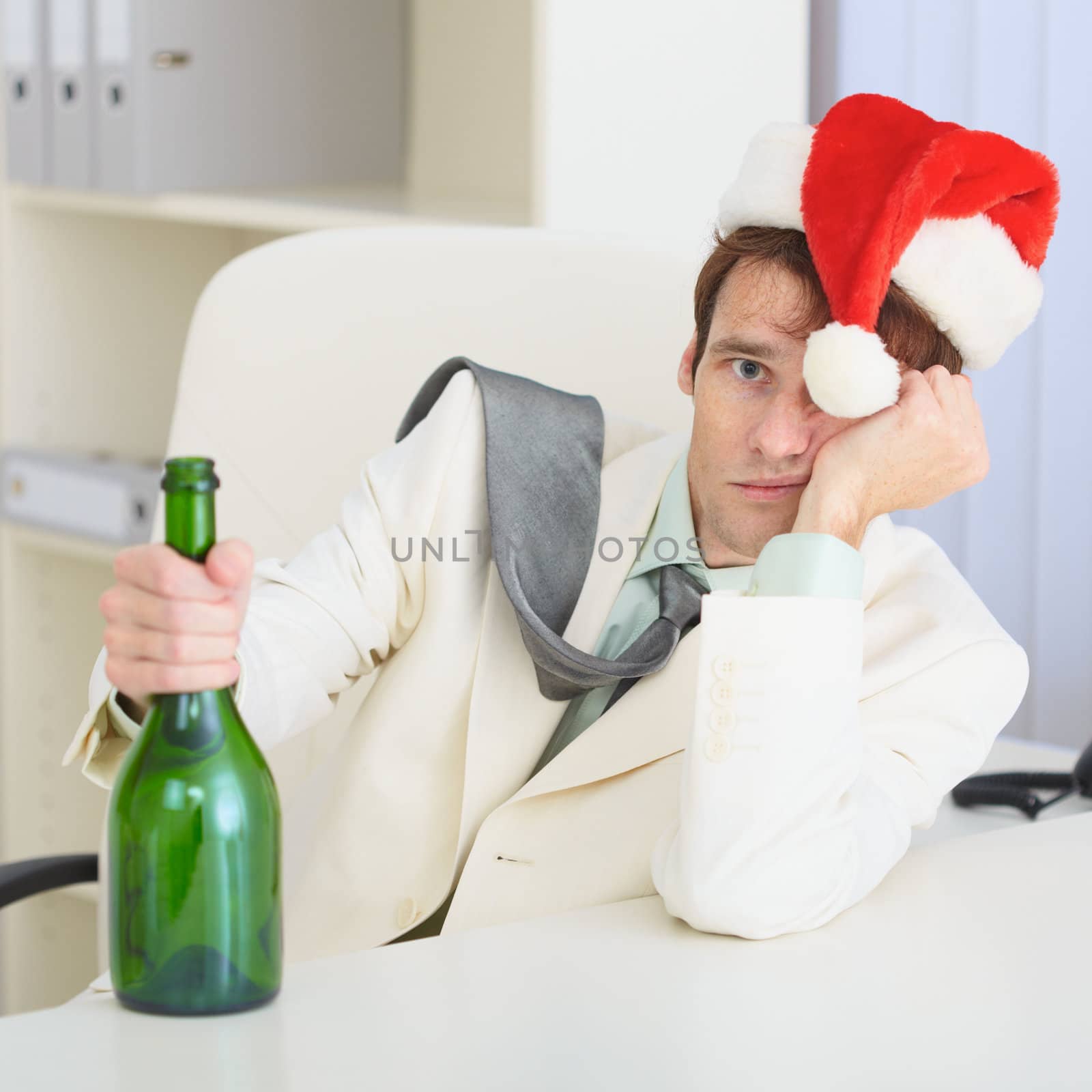 The young drunkard celebrates Christmas with a wine bottle