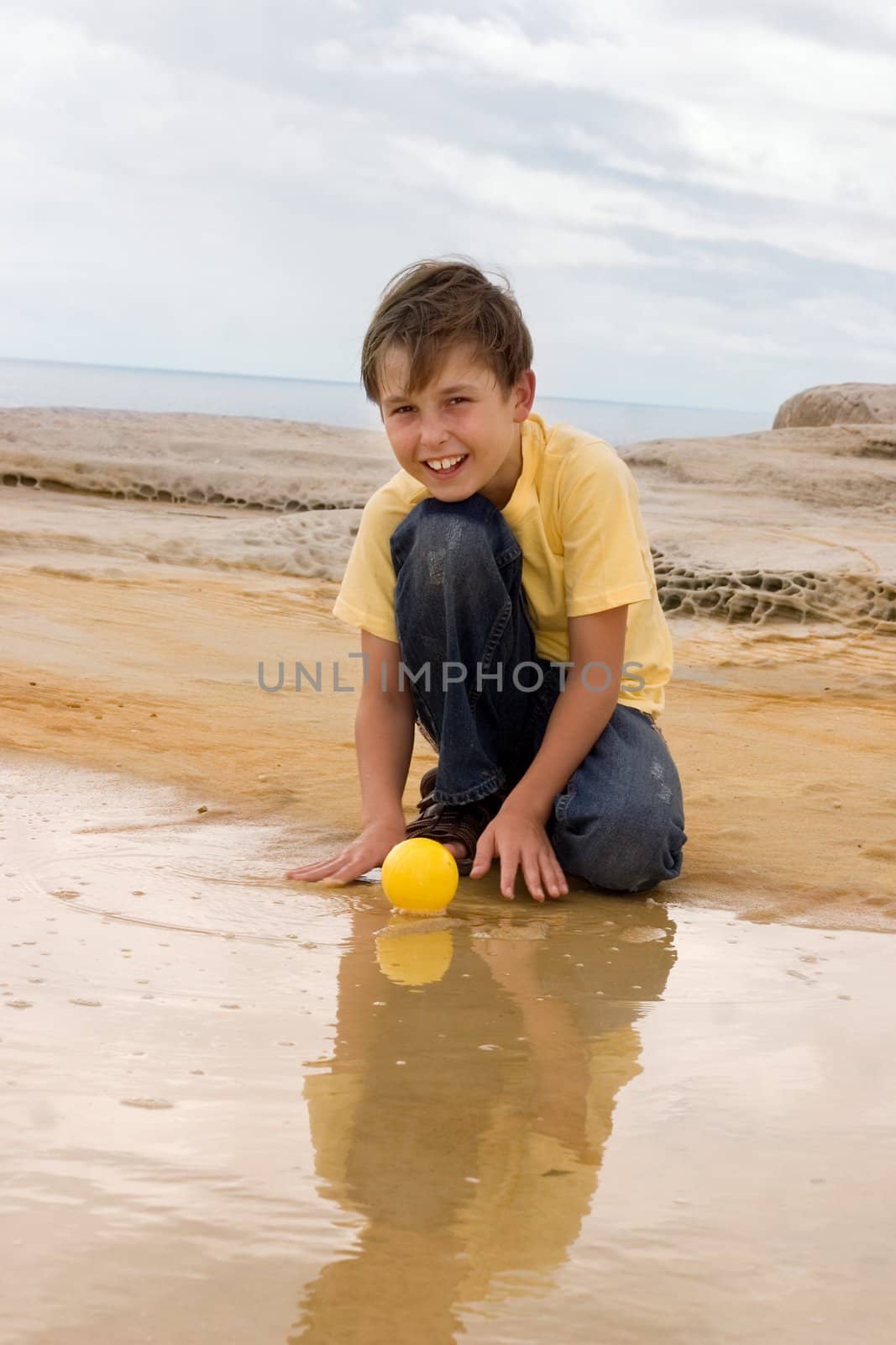 Child plays with a ball in water.