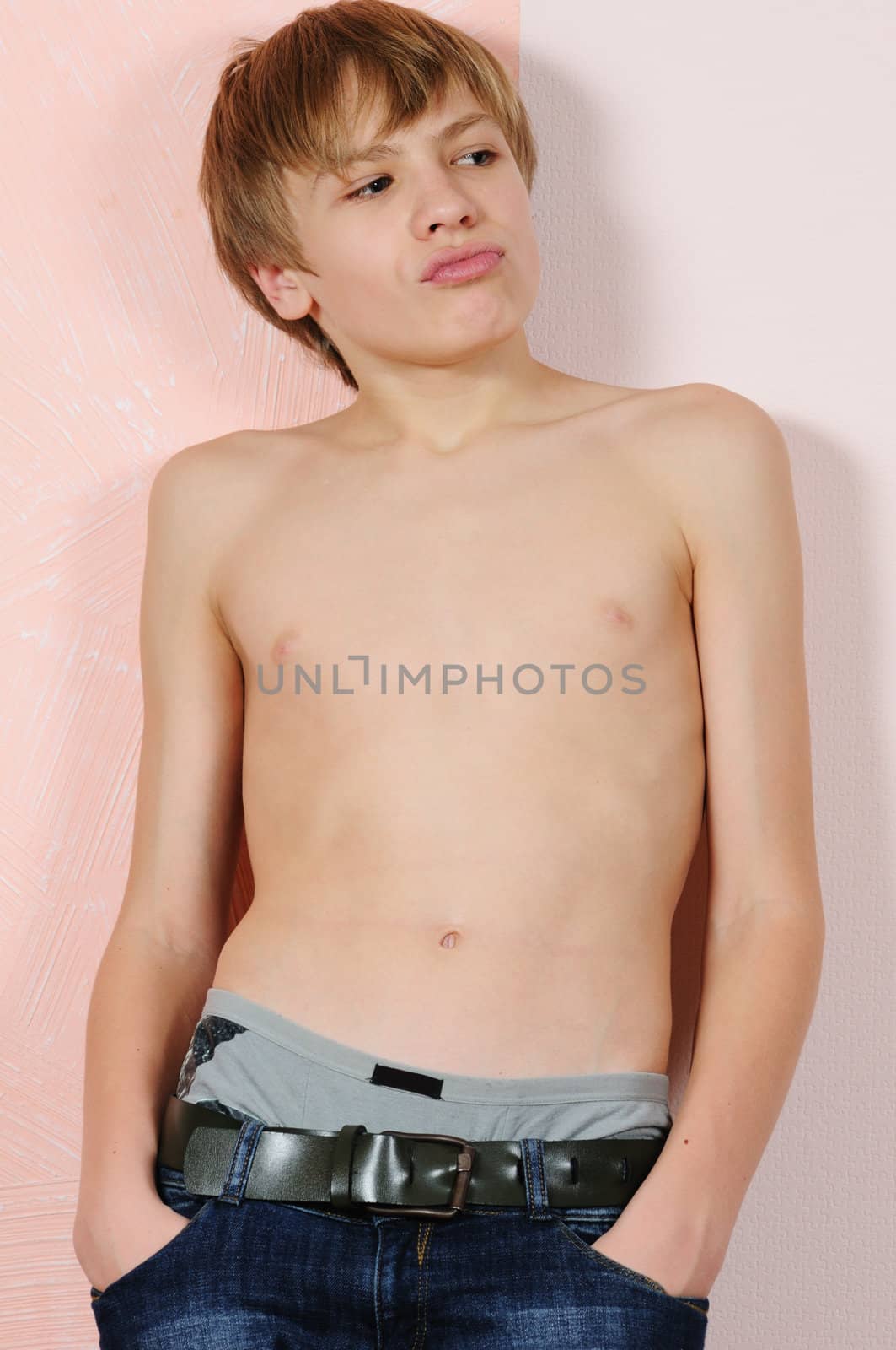 The teenager without a shirt near a wall