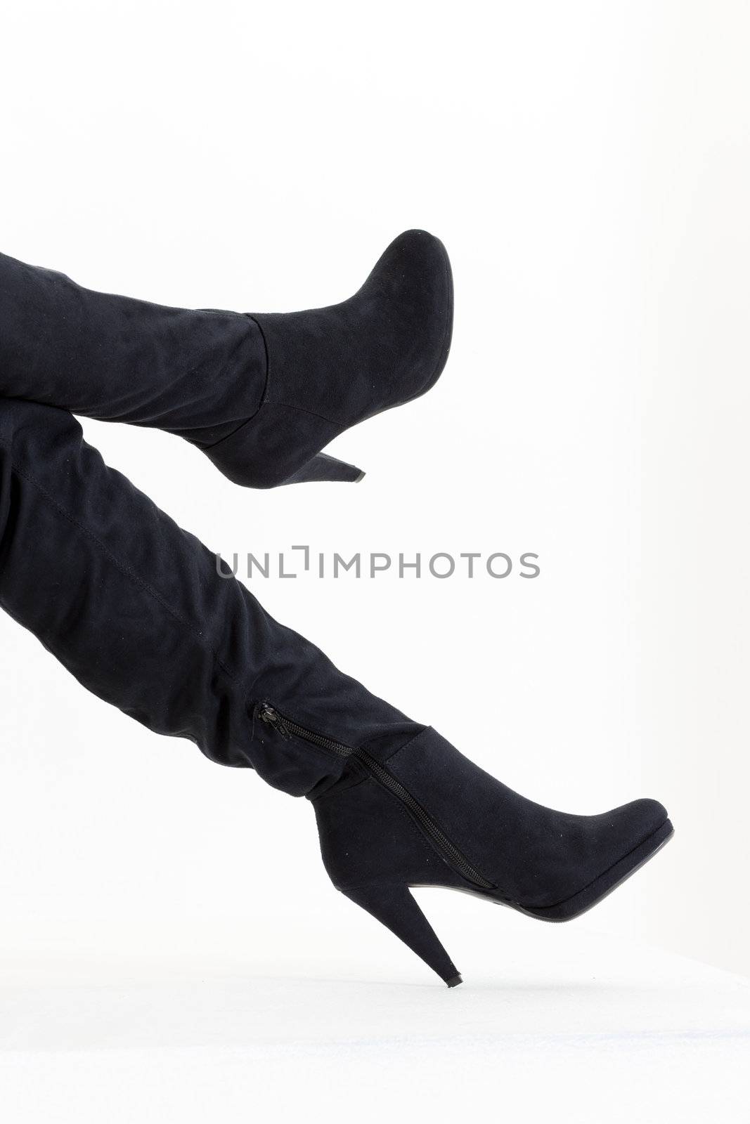 detail of sitting woman wearing fashionable black boots