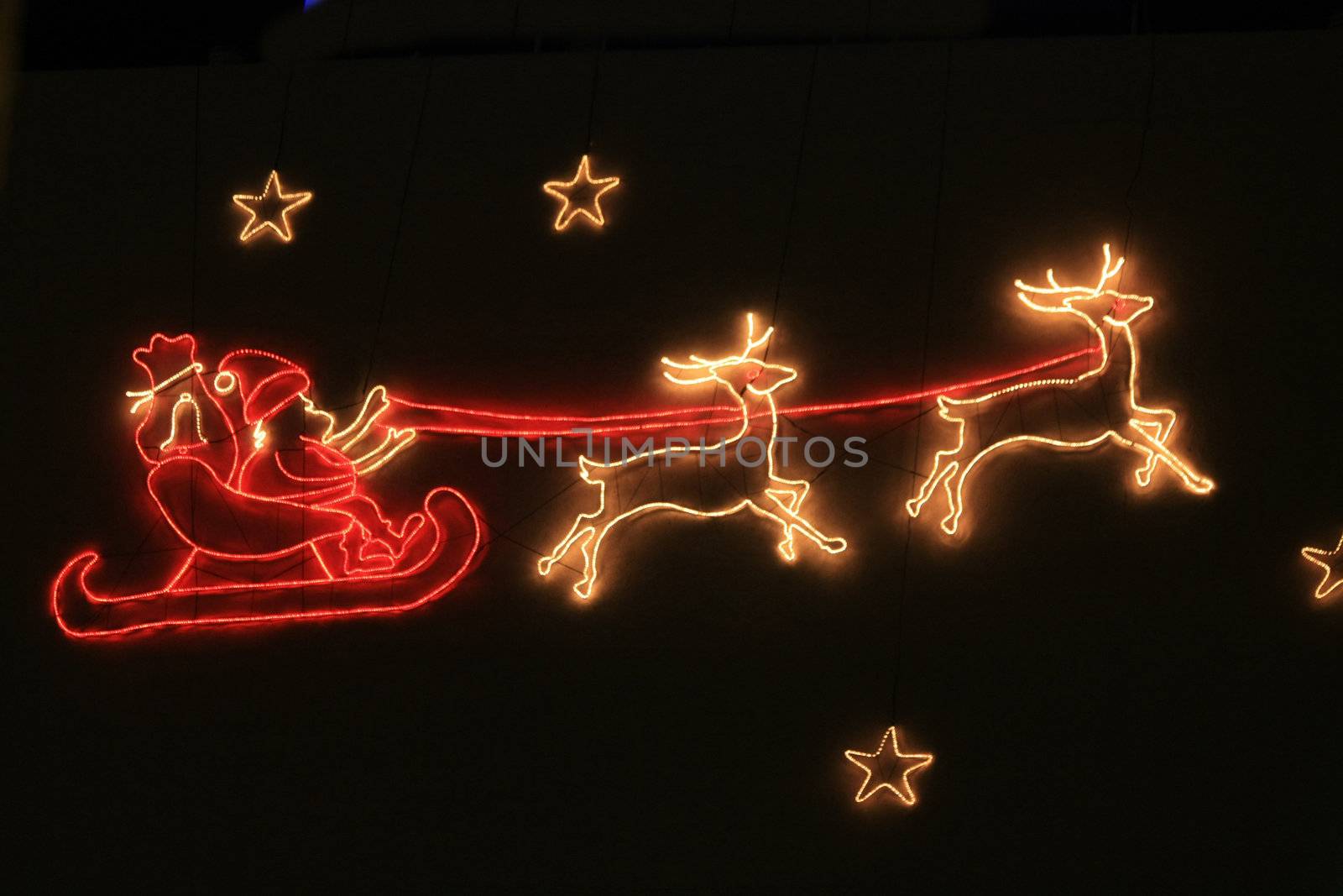 A holiday decoration lightning, santa claus and his sleigh