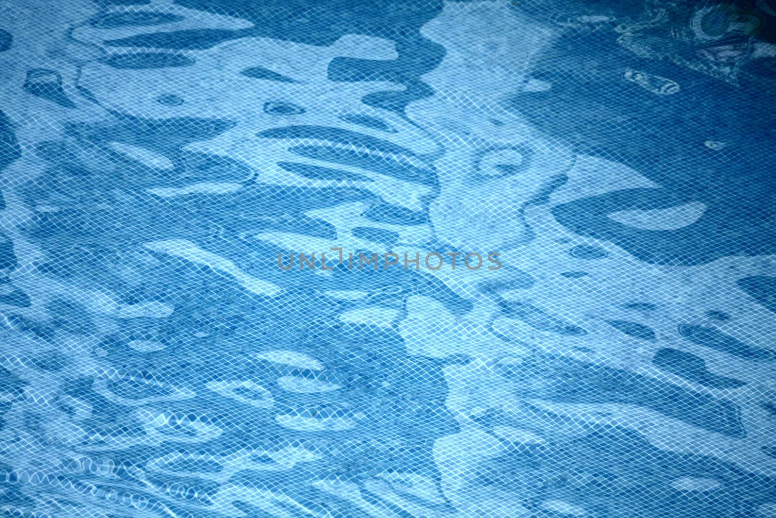 Blue tile pattern and sun reflecting water in a swimming pool