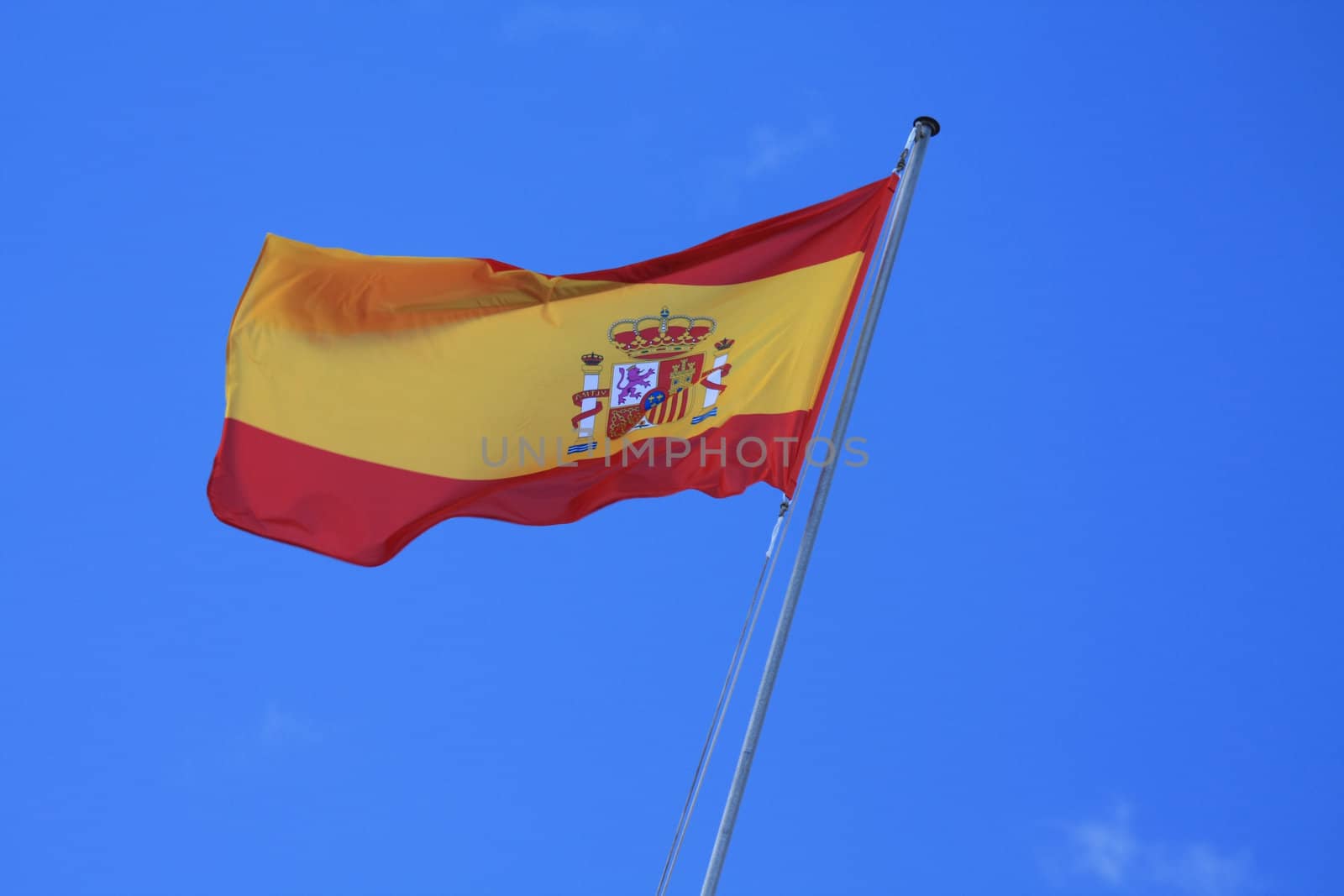 the flag of Spain, yellow and red in a blue sky