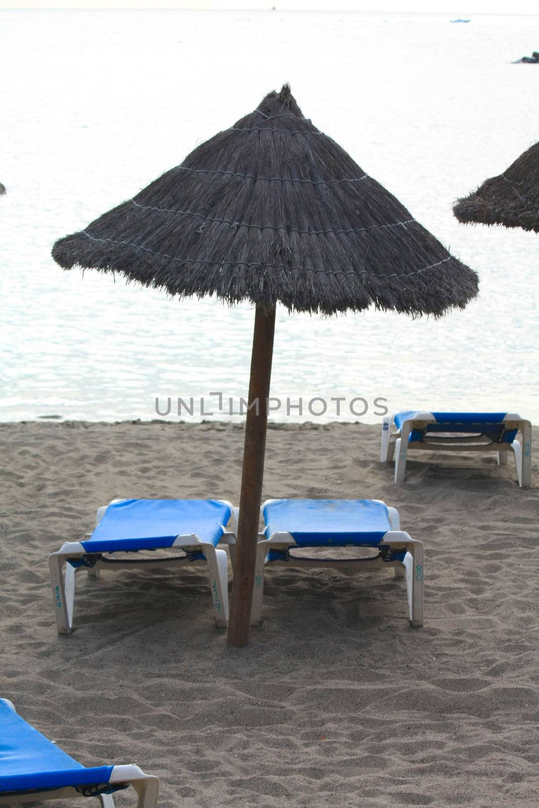 Two beach chairs and an umbrella