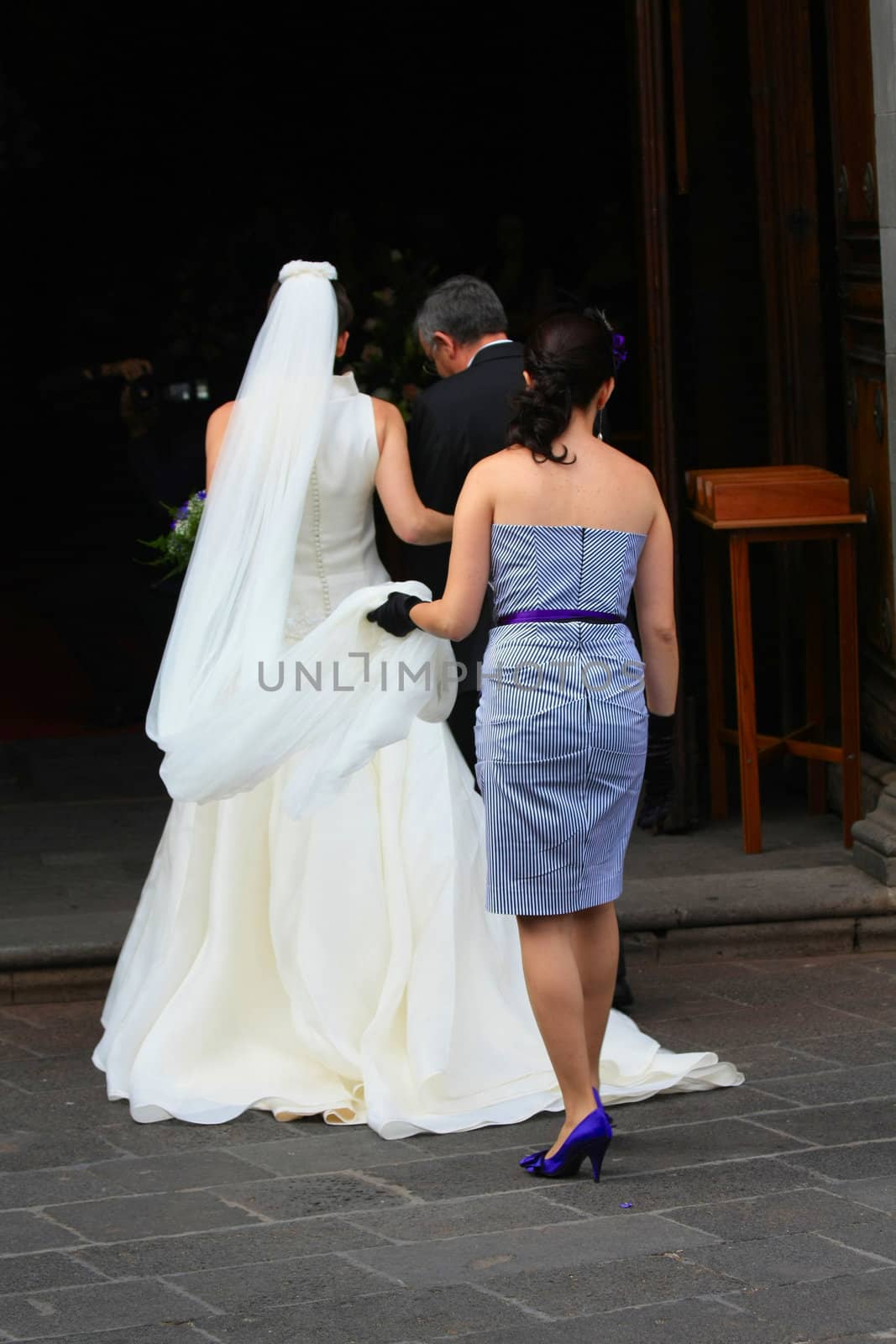Bride entering the church by studioportosabbia