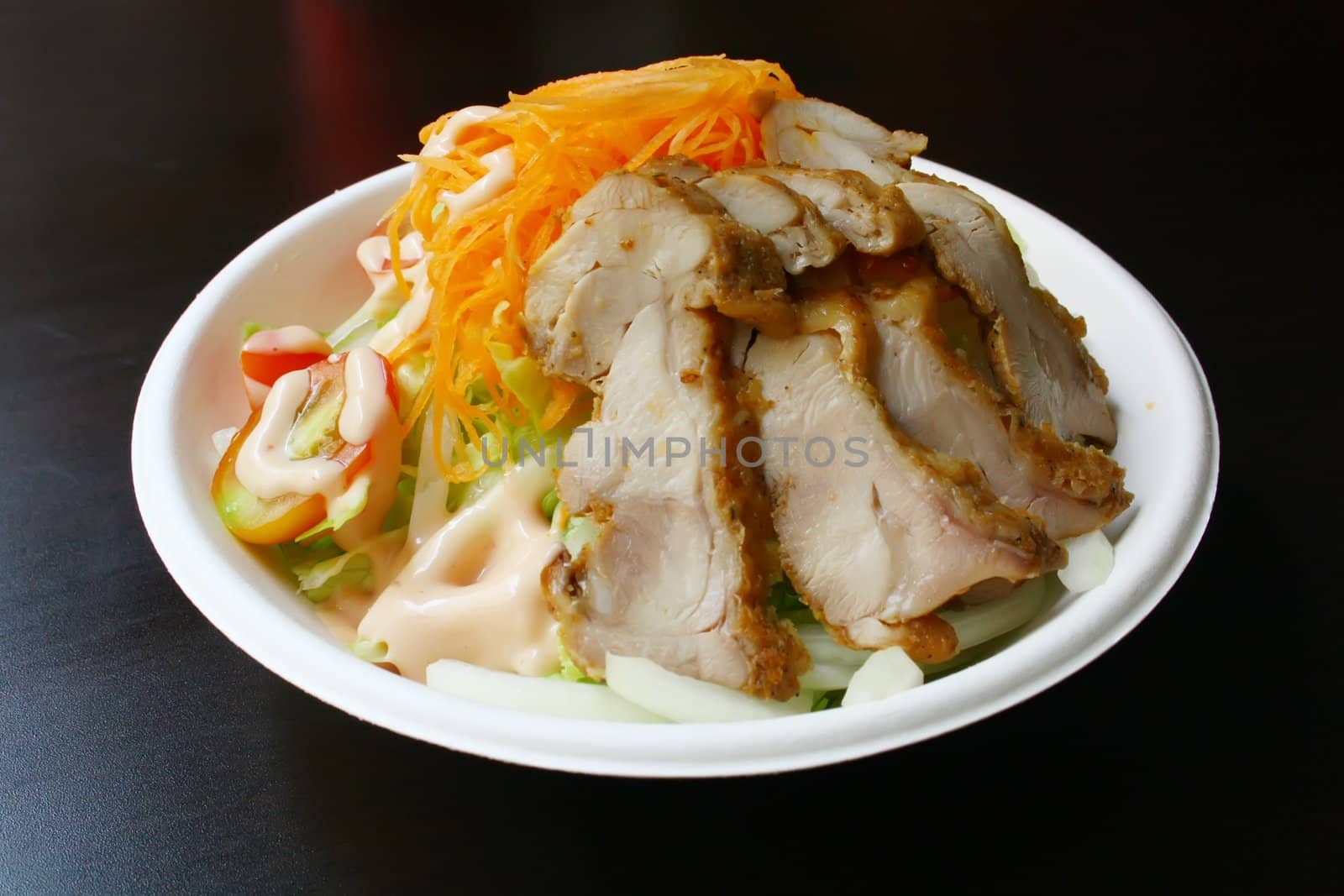 Salad With Chicken Slices on a Black Texture Table