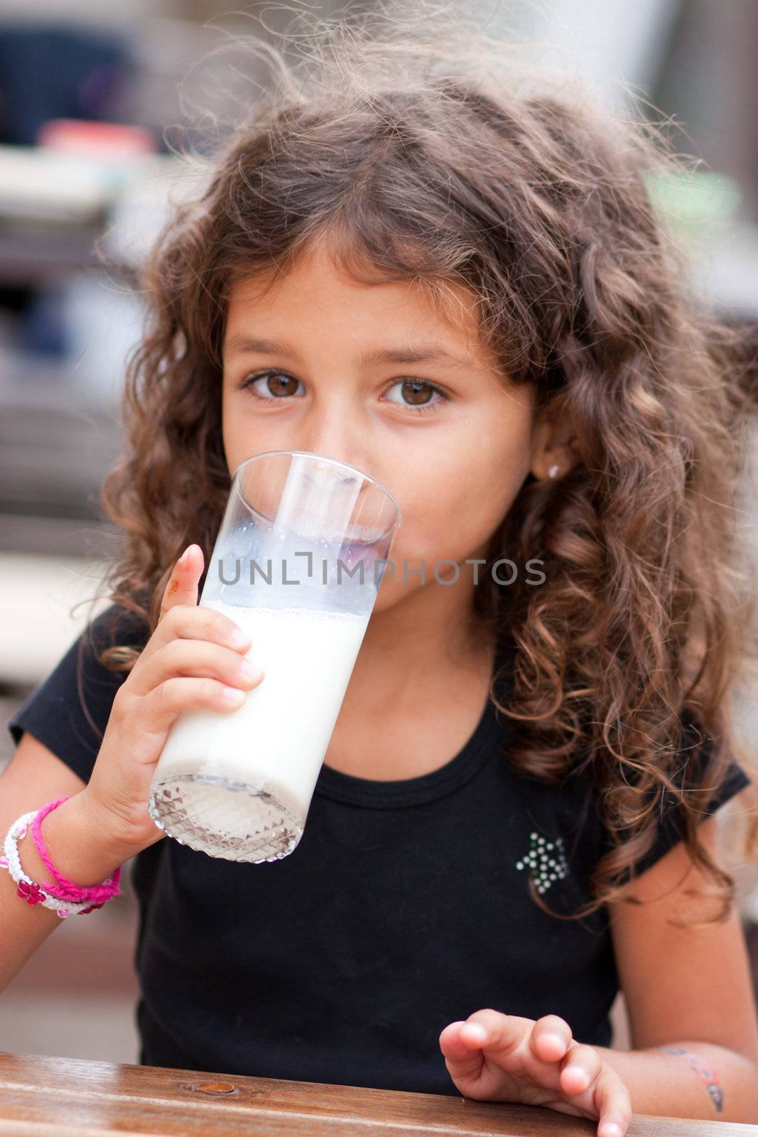 Cute little girl drinking a glass of milk