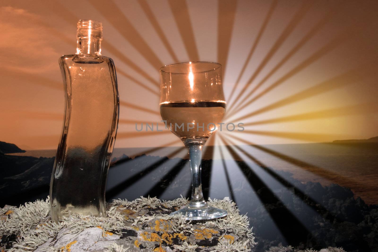 single bottle and a glass of pure natural water standing on the rocks on a beach in ireland showing a clean environment at sunset