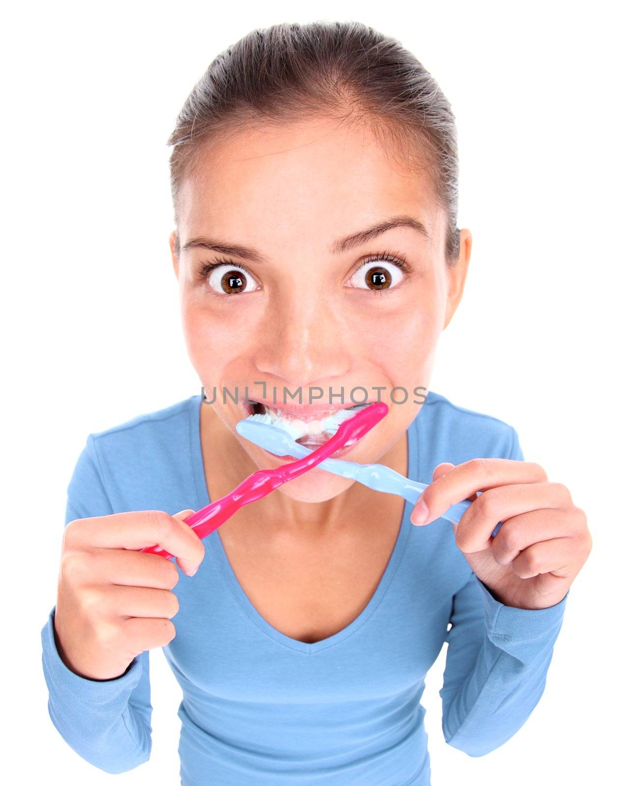 Funny woman with two toothbrushes brushing teeth. Isolated on white background. Concepts could be: 1) Being too busy and stressed in the morning and desperate to win some time. 2) Being obsessed with personal hygiene. 3) ?