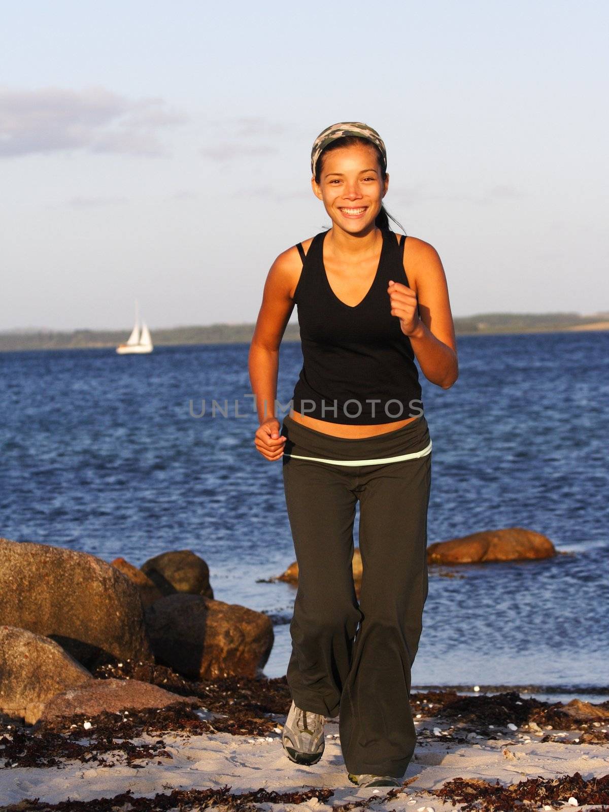 Woman running on beach by Maridav