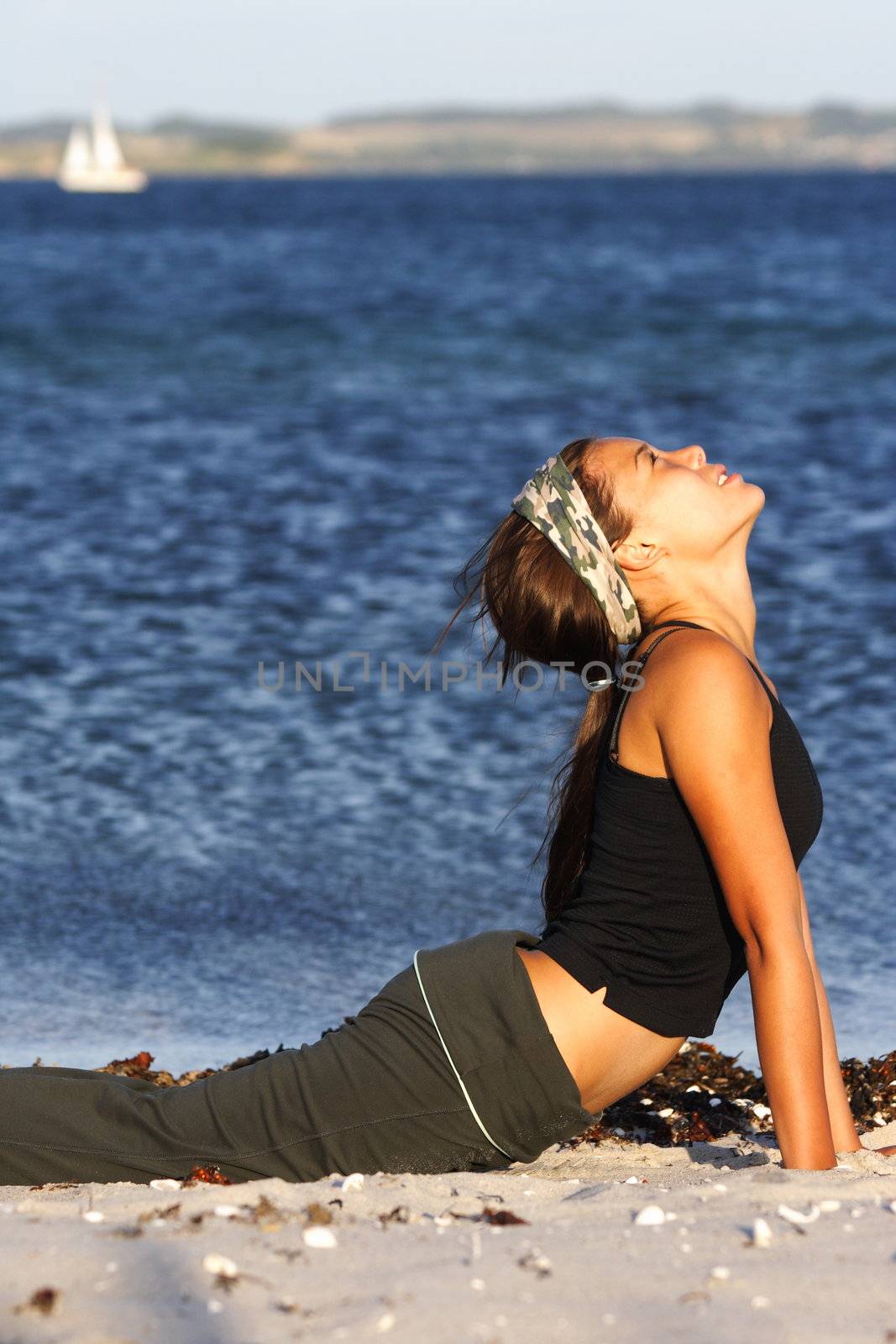 Woman stretching during a workout on a beach