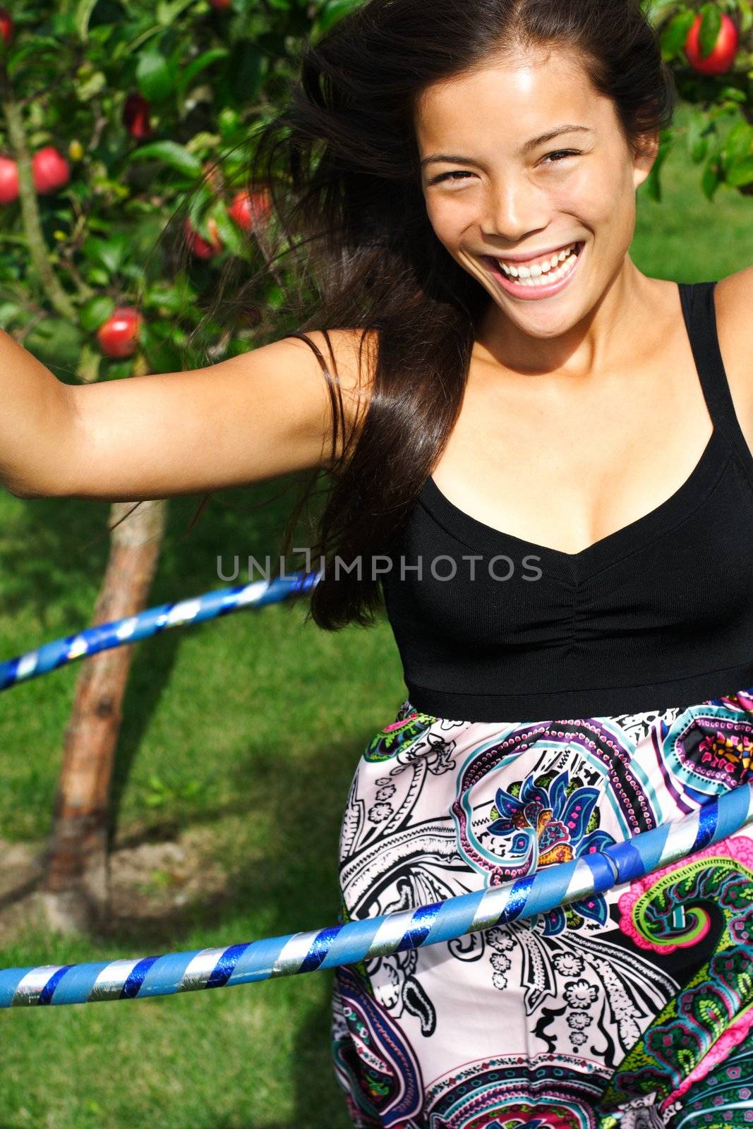 Hula hoop. Beautiful young woman having fun doing hula hoop outdoors in the fall