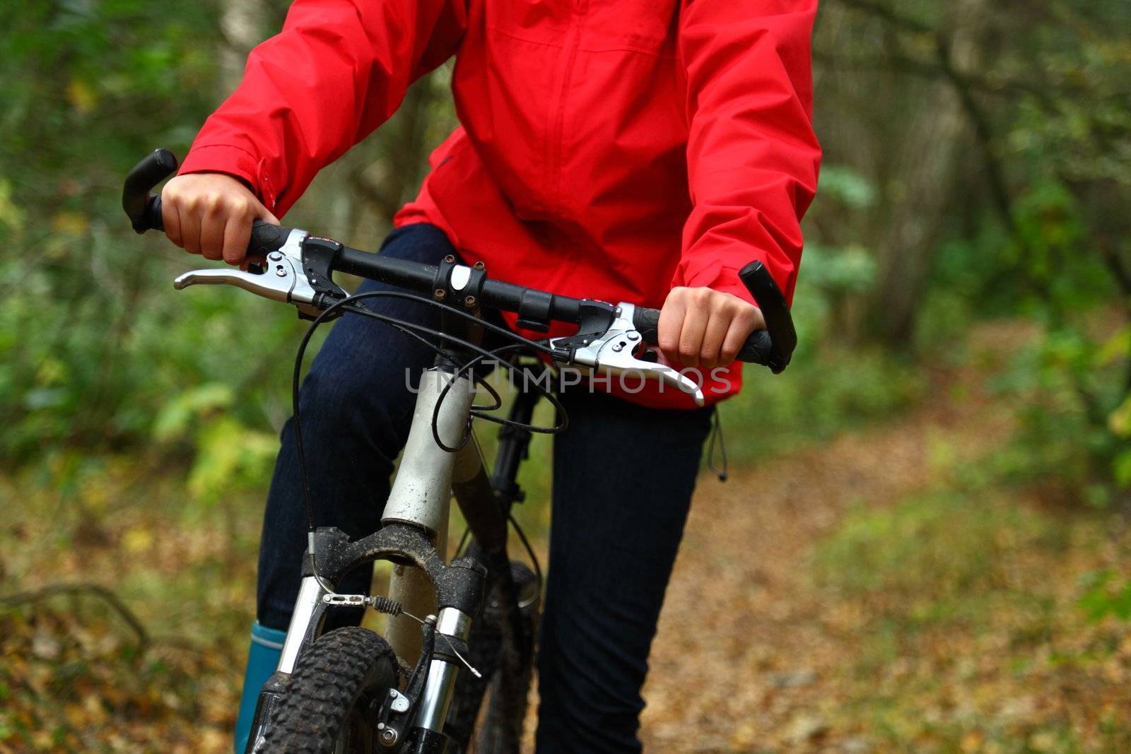 Biking. Woman on mountainbike in autumn forest.