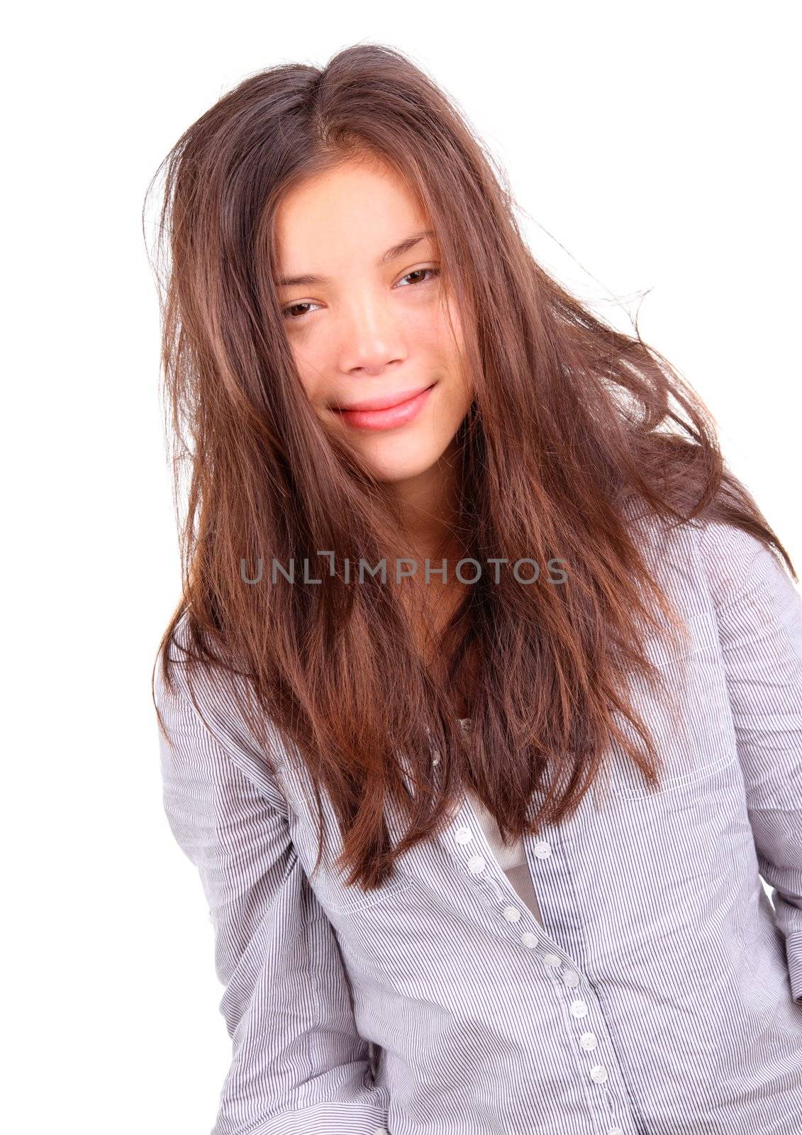 Morning Hair. Tired woman with very messy long morning hair and a silly smile - just out of bed. Beautiful mixed chinese / caucasian model isolated on white background.