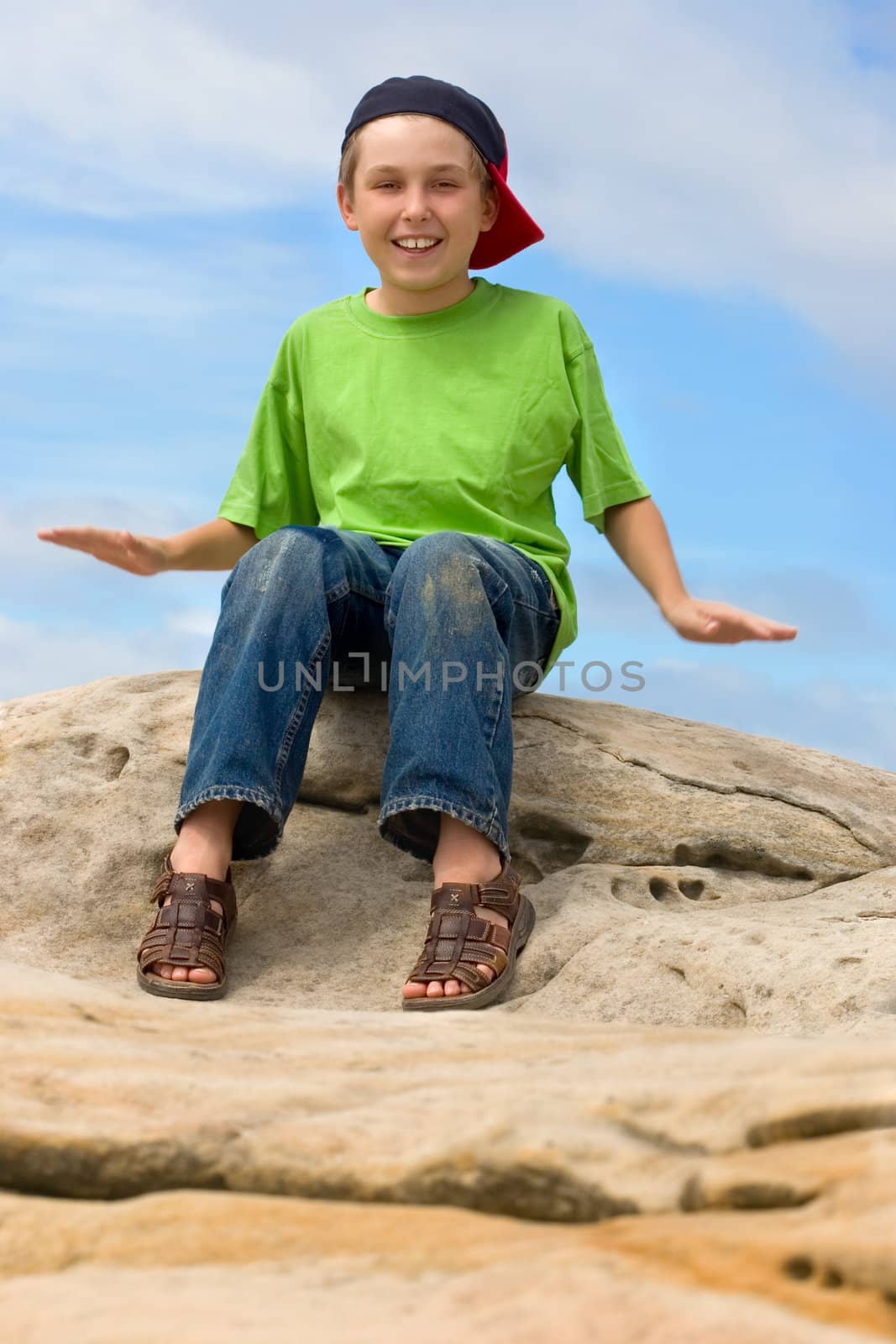 A child outdoors having fun with happy expression.  Movement in arms.