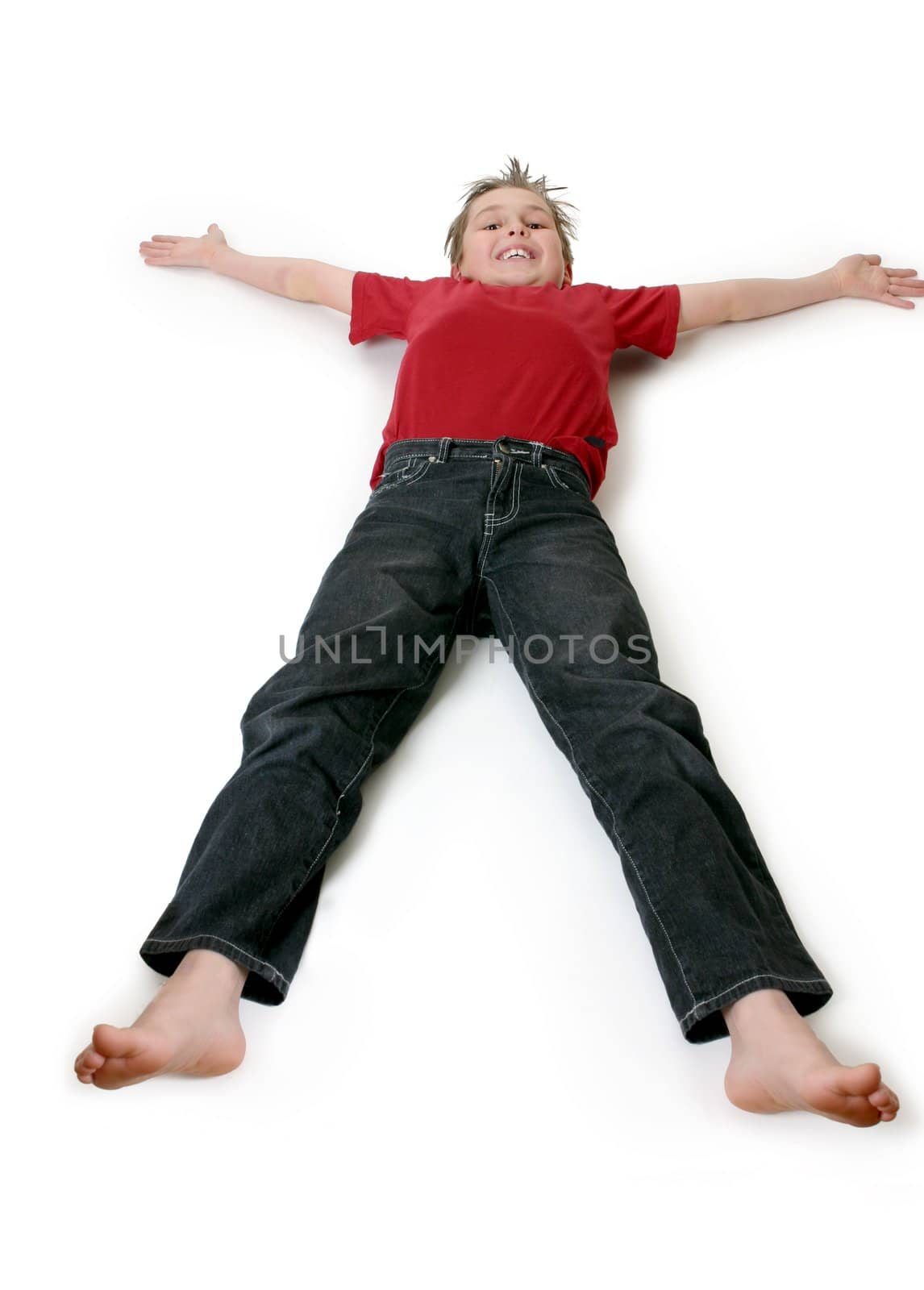A boy lies outstretched on a floor.