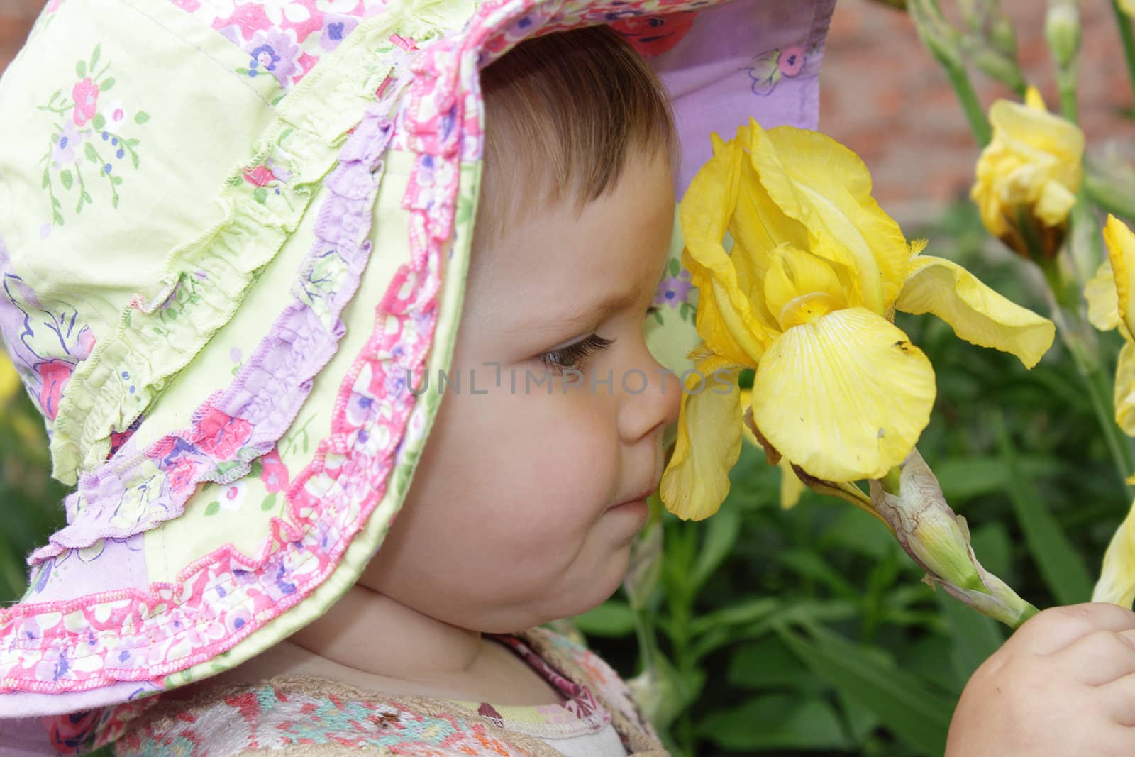 Cute little girl with yellow flower in the garden