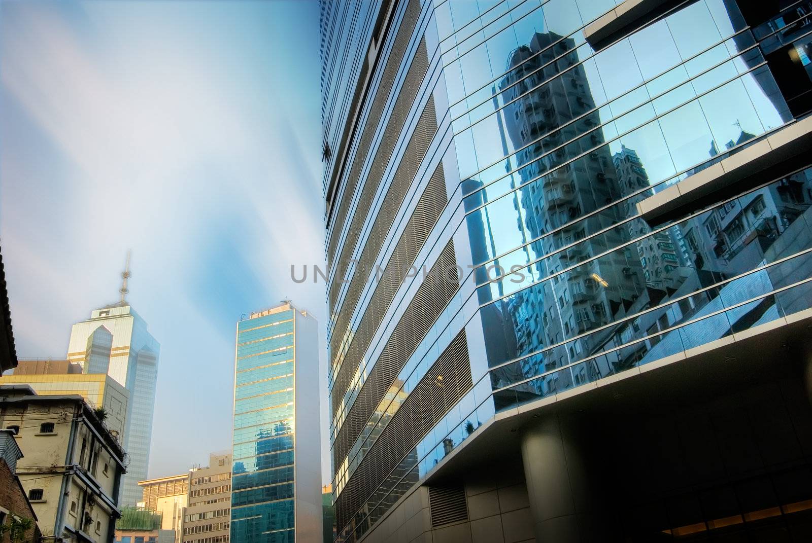 Skyscraper stands on the street with blue sky and white clouds.
