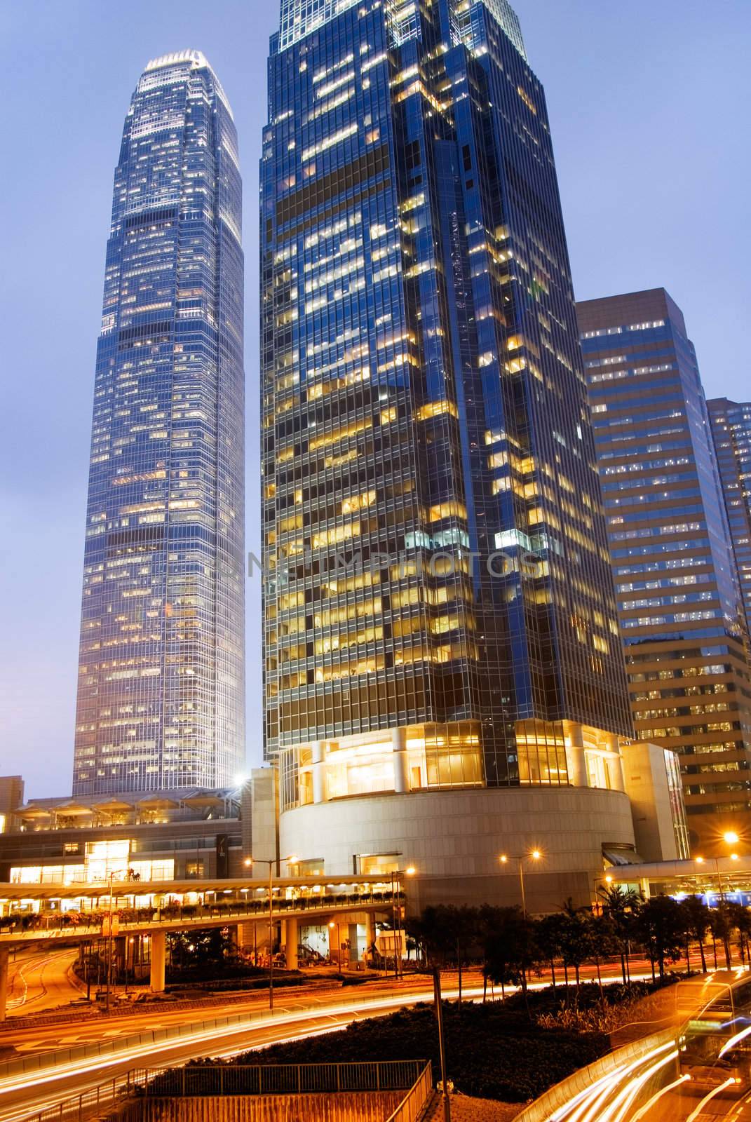 It is skyscraper with traffic light and cars motion blurred in Hong Kong.