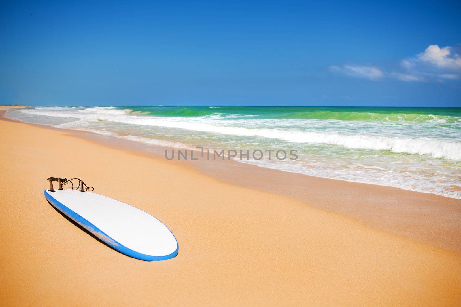 Surfboard on a sandy beach by mihhailov