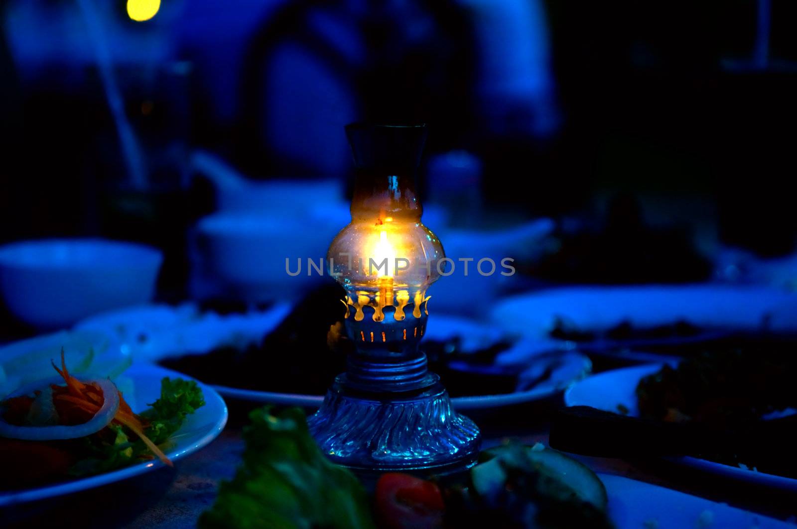 Dishes of food and evening lamp for illumination