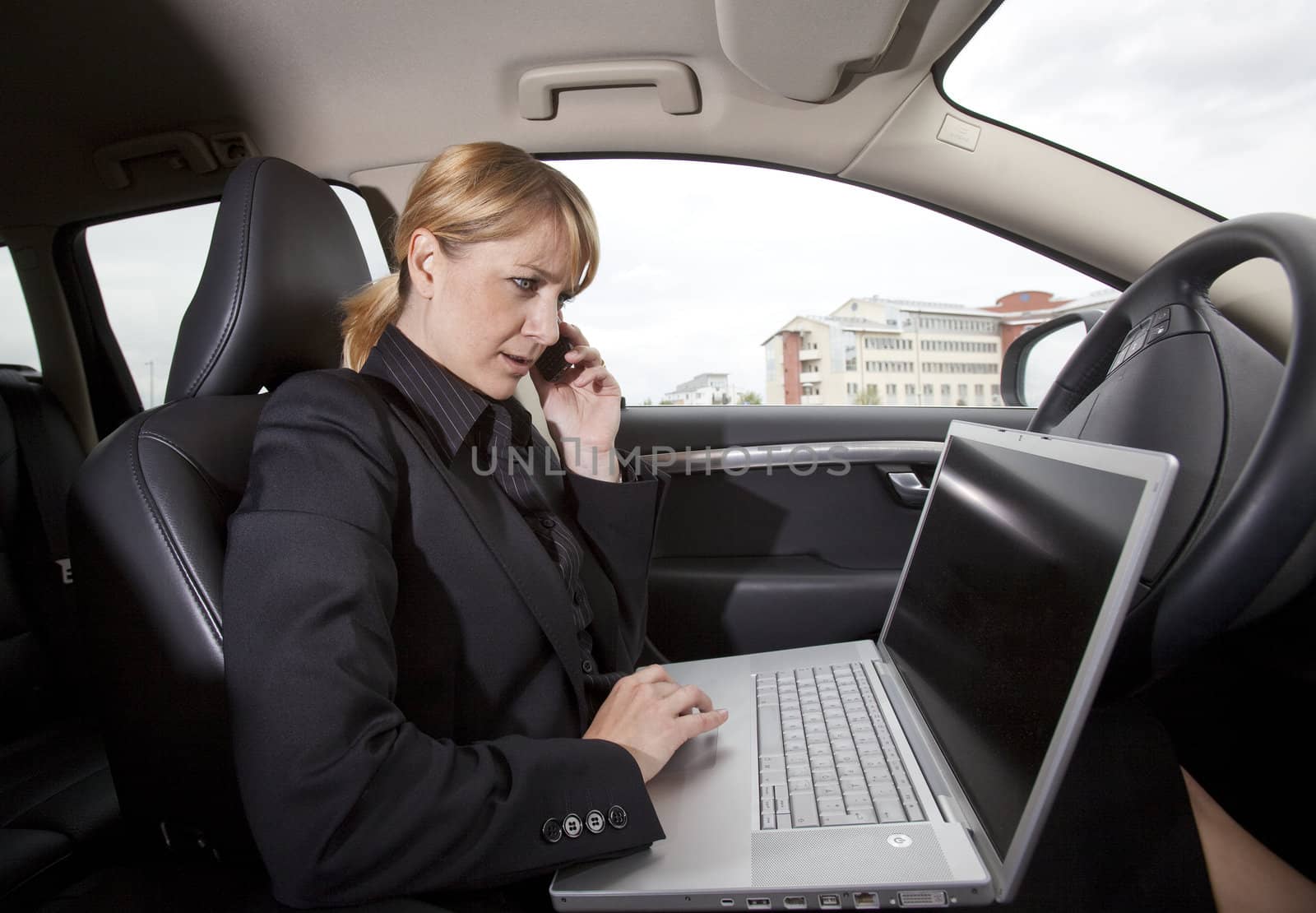 Businesswoman with a laptop in her car by gemenacom