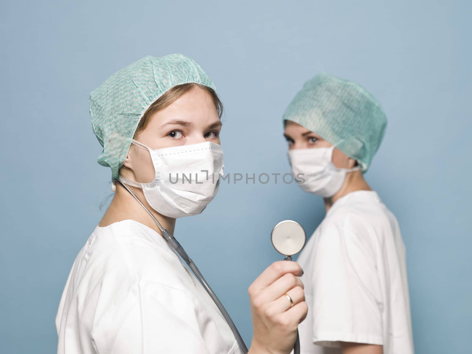 Two female nurses with surgical masks and a stethoscope