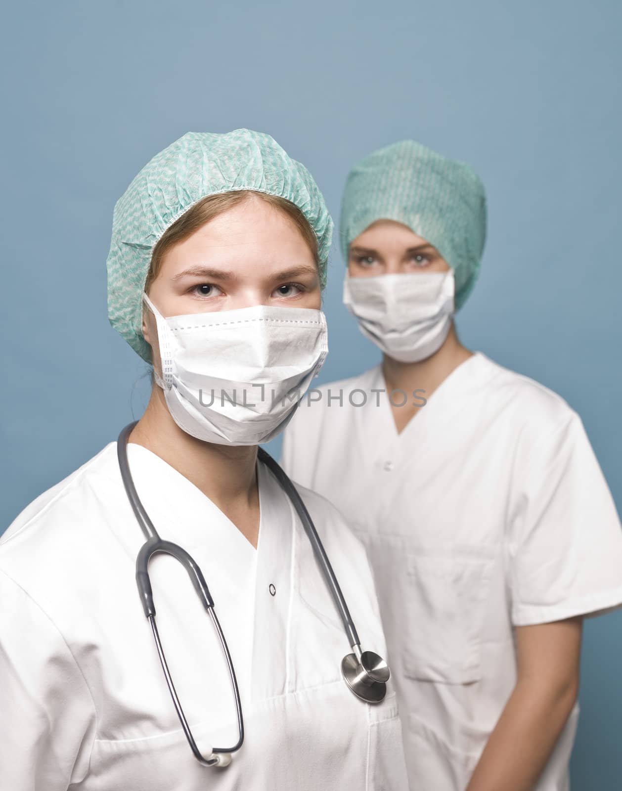 Two nurses with surgical masks and a stethoscope by gemenacom