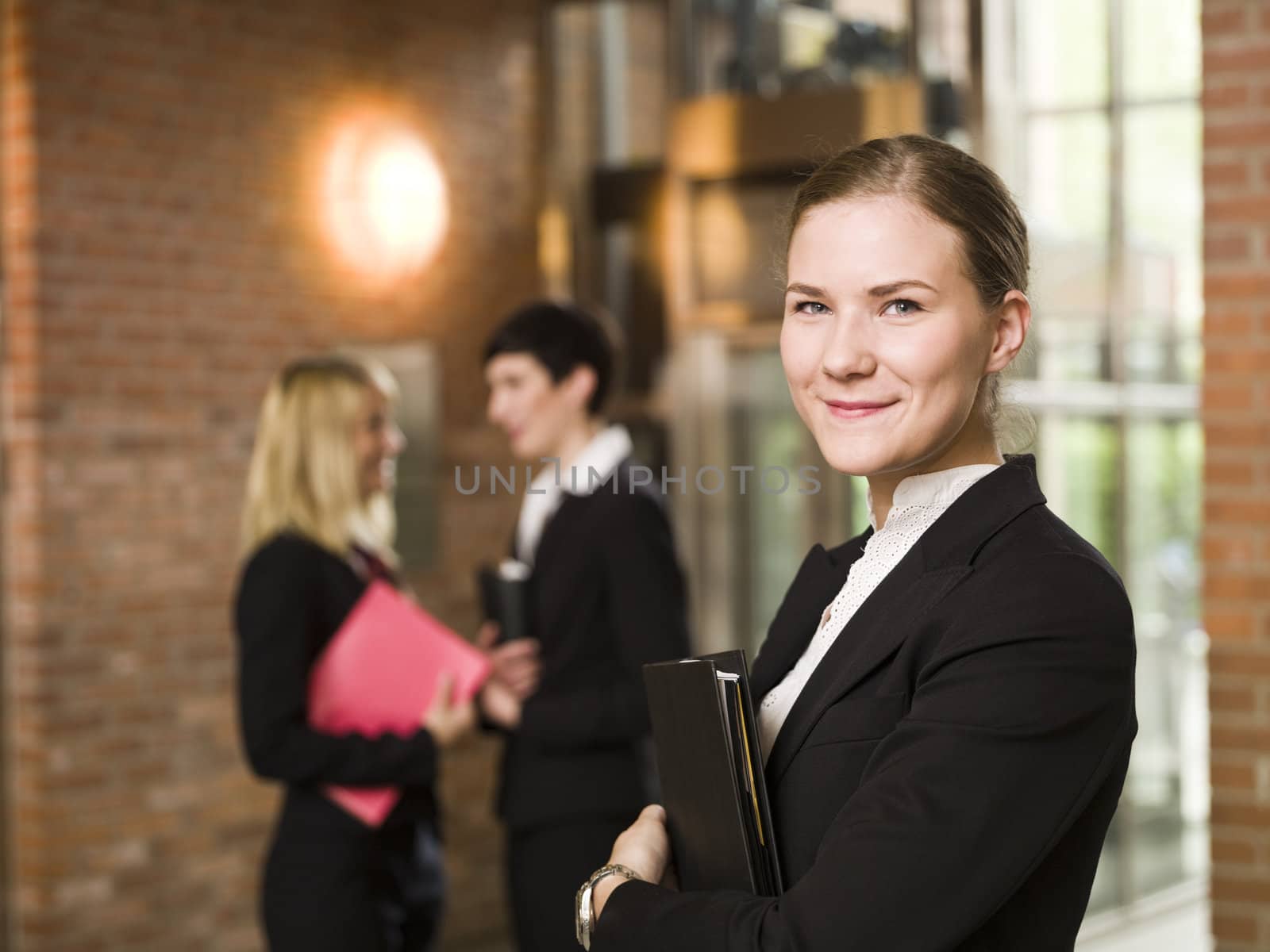 Smiling businesswoman in front of her team by gemenacom