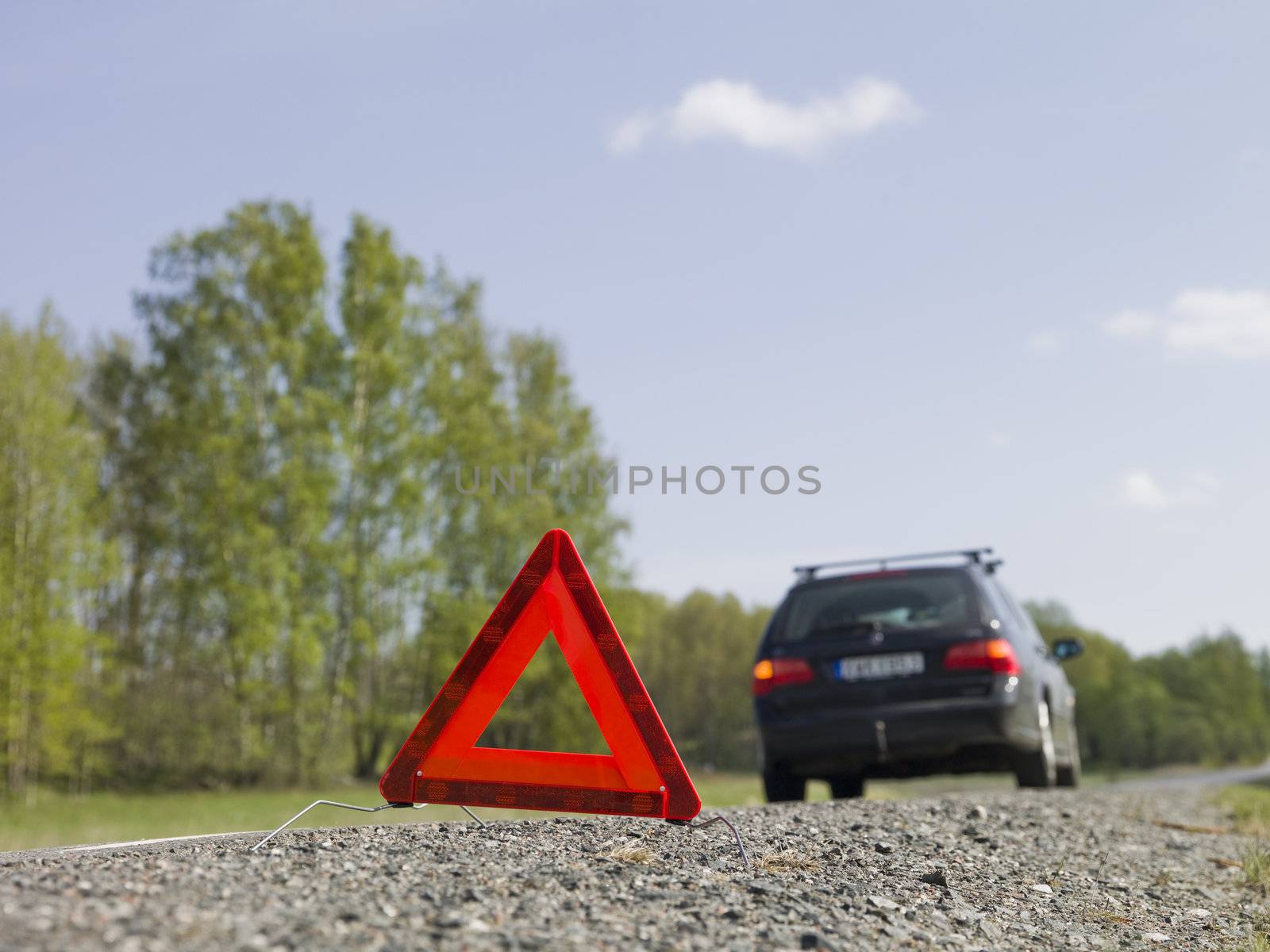 Warning triangle in front of a car breakdown