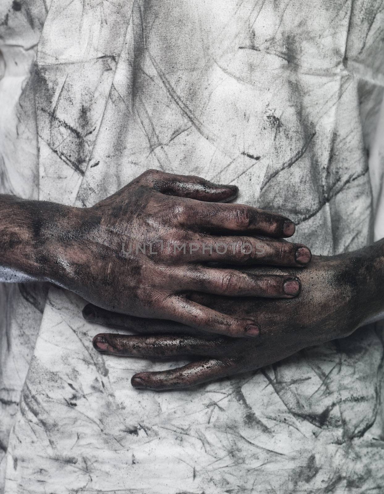 Very dirty hands in front of a dirty shirt