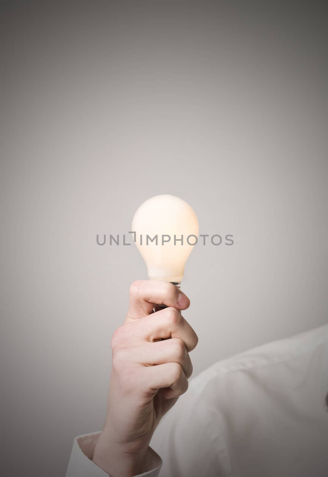 Hand holding shining light bulb