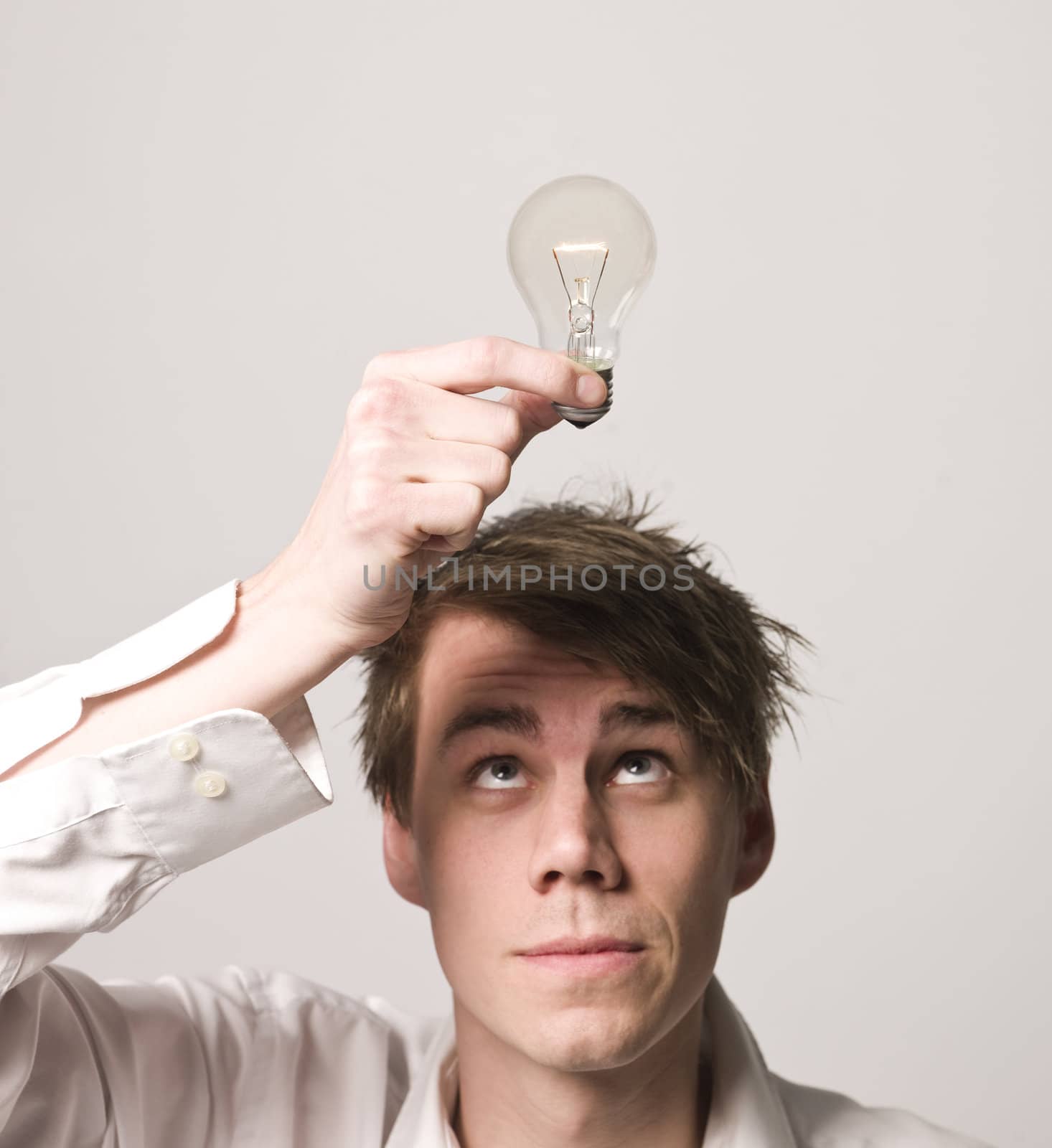 Man holding electric light bulb over his head