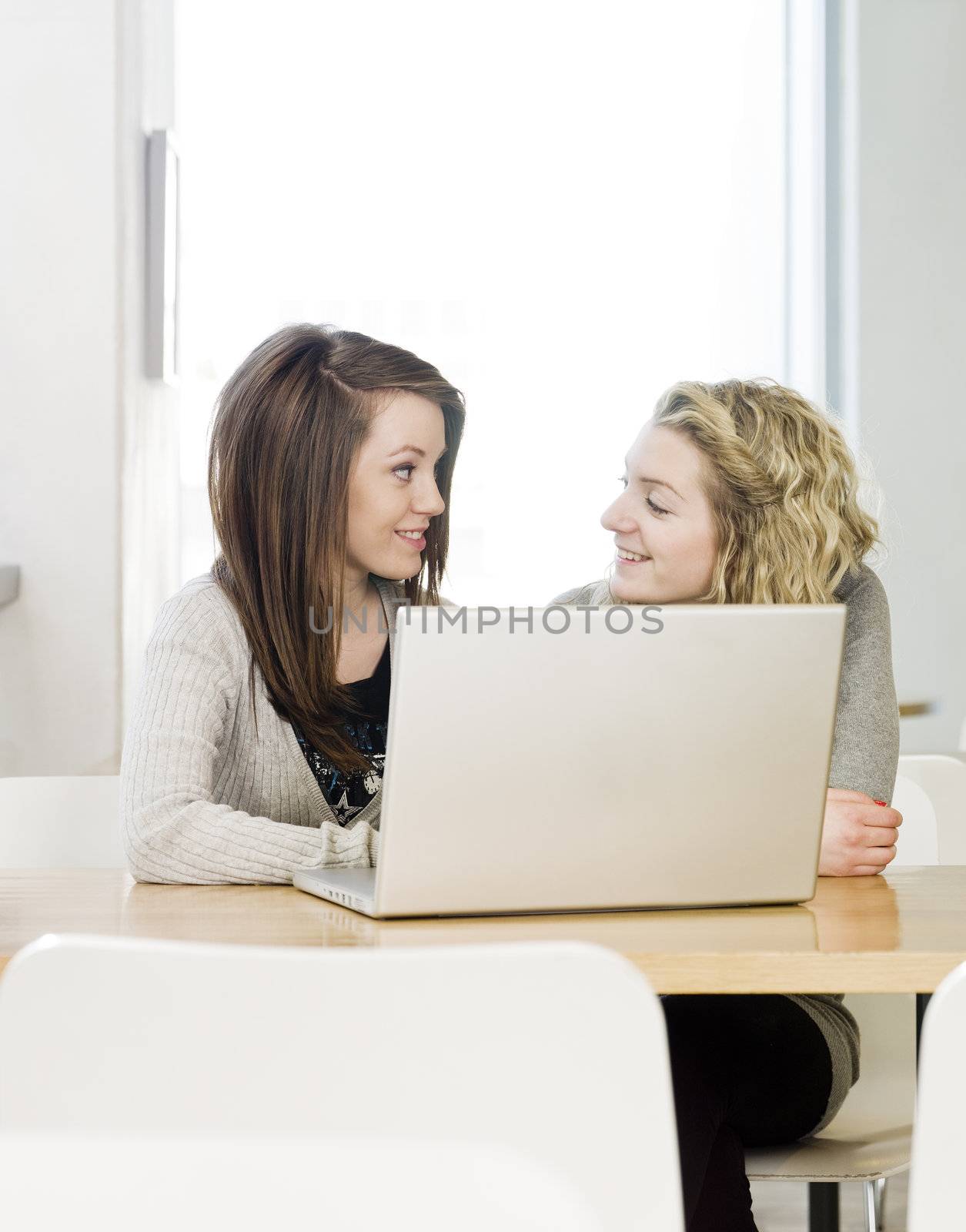 two girls using a laptop