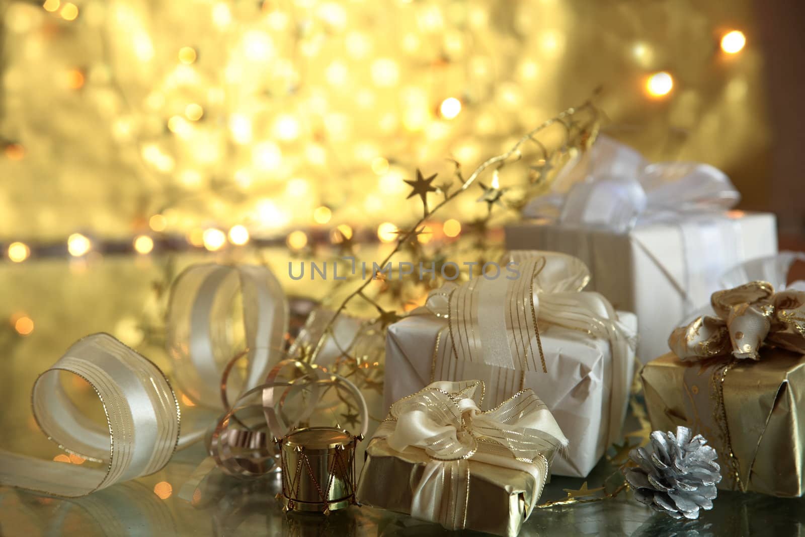 Closeup of gift boxes on golden background with blurred lights.