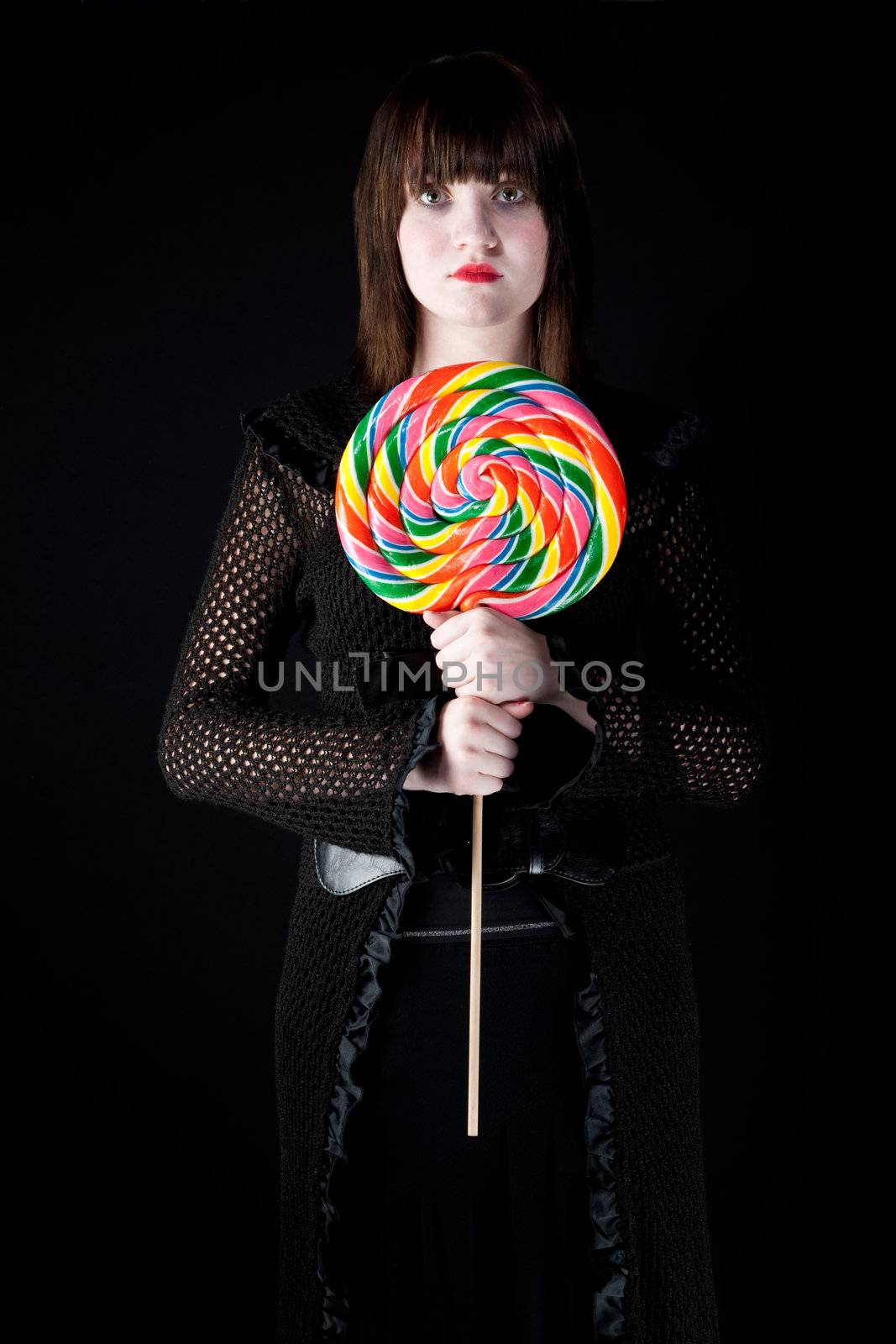 Pretty emo girl with bright colorful lollipop