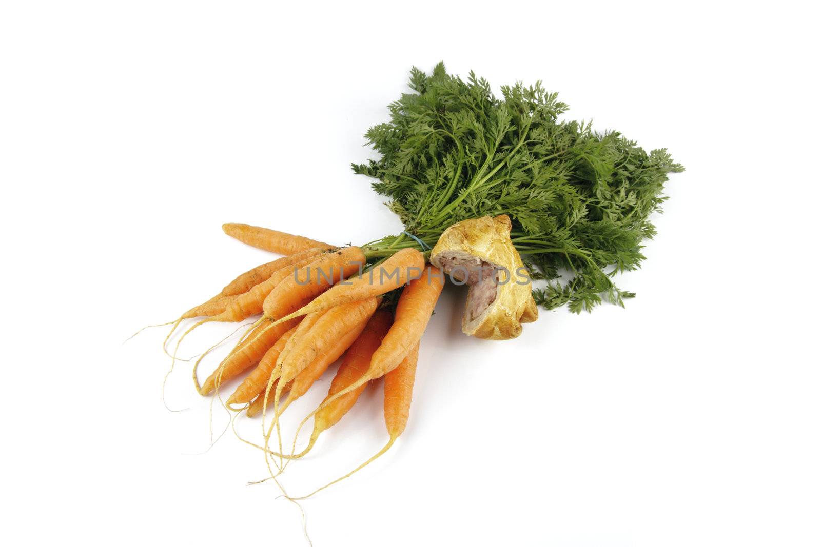 Contradiction between healthy food and junk food using bunch of carrots and pork pie on a reflective white background 