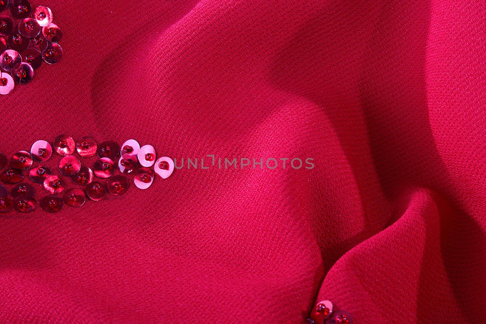 Darkly red fabric with an embroidery from seed bead for use as a background.