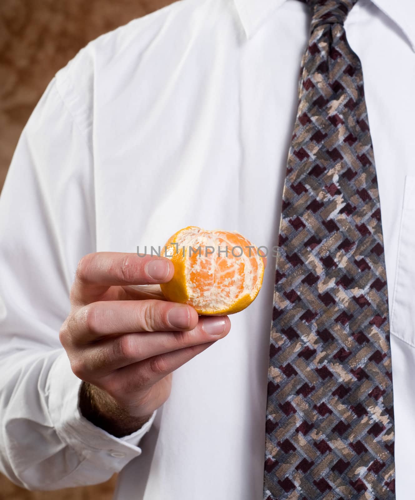 Closeup view of a businessman showing a partially peeled orange