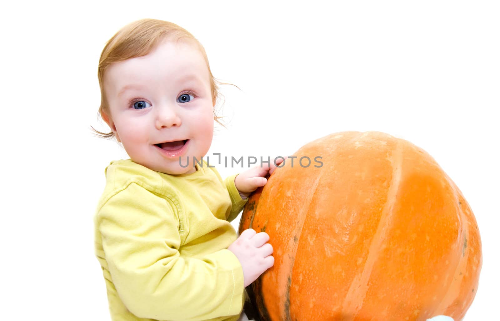 Smiling baby boy playing with pumpkin over white