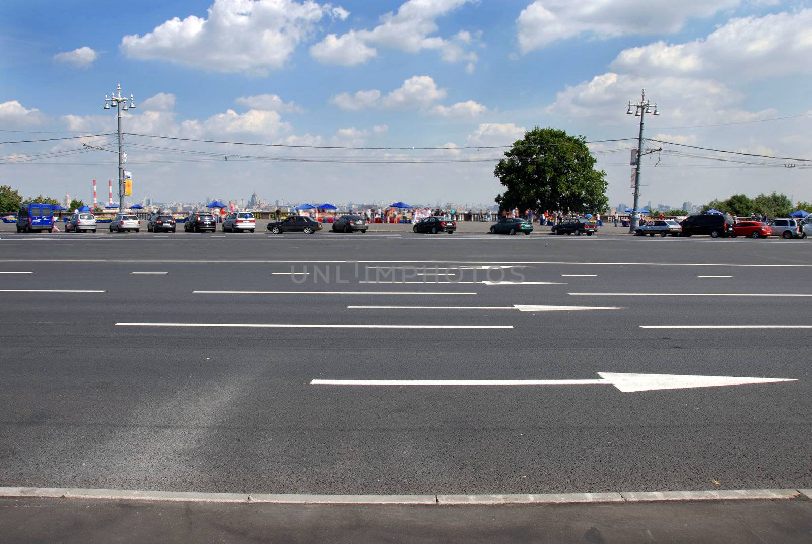wide empty street in Moscow, cityscape behind parked vehicles
