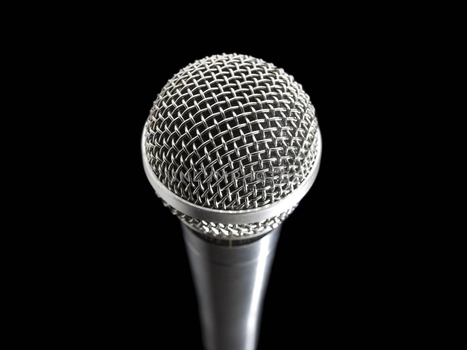 A dynamic microphone over a black background.