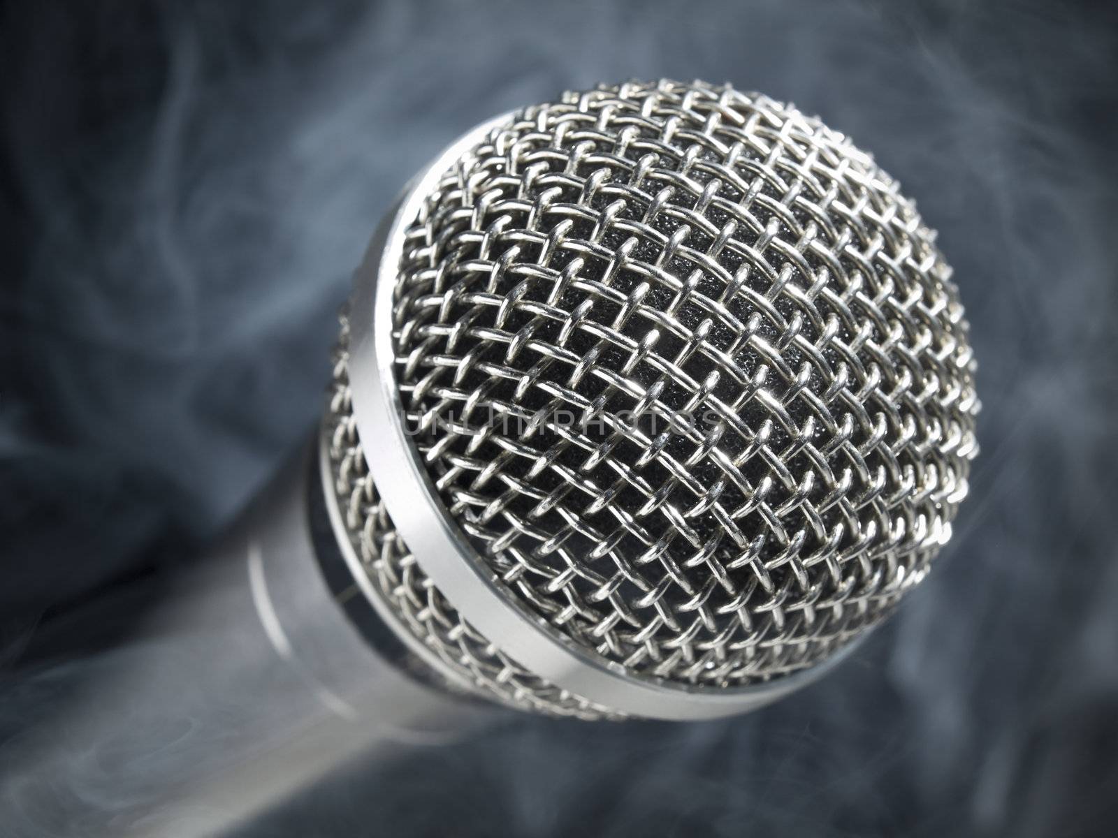 A dynamic microphone over a black and smoky background.