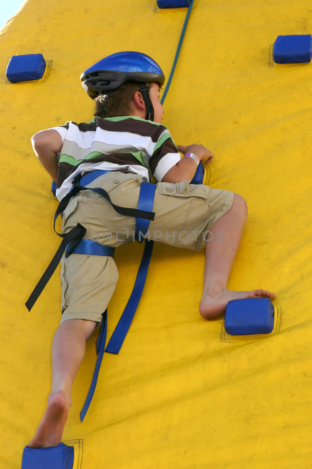 Child climbing a climbing wall by lovleah