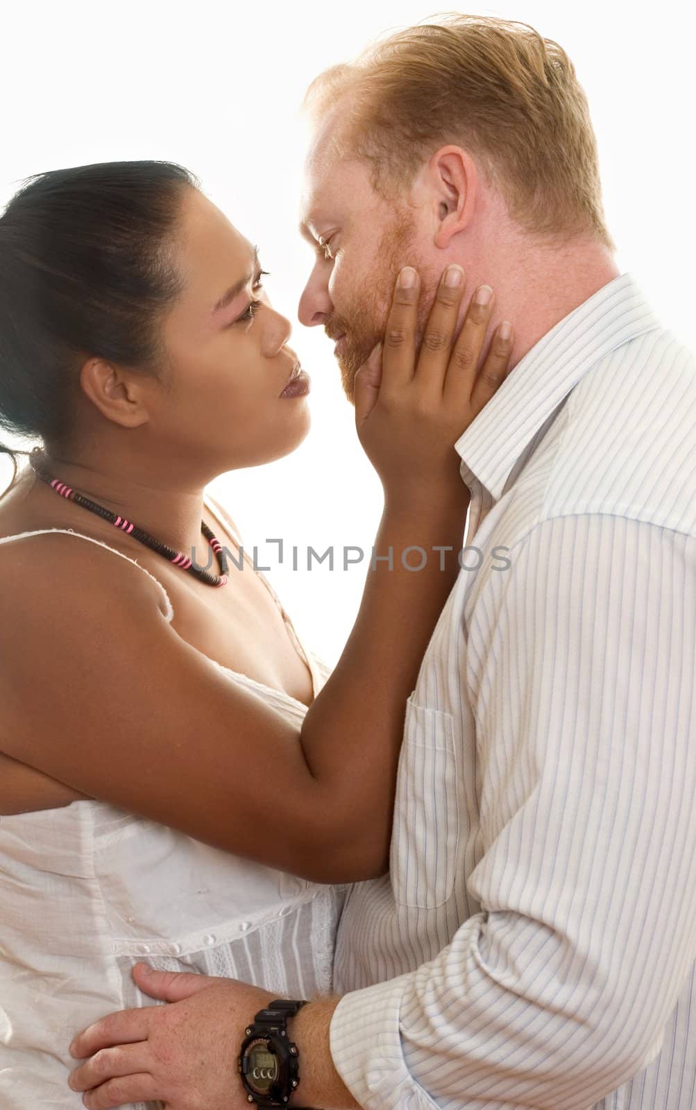 Mixed race couple look lovingly into one another eyes