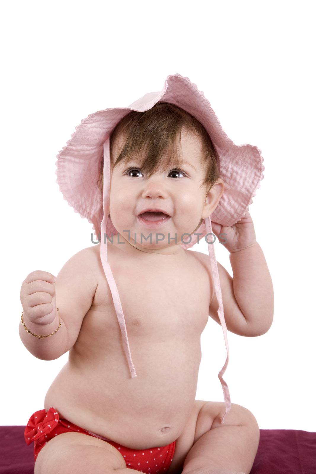Cute little baby girl with a swimming trunk and a summerhat