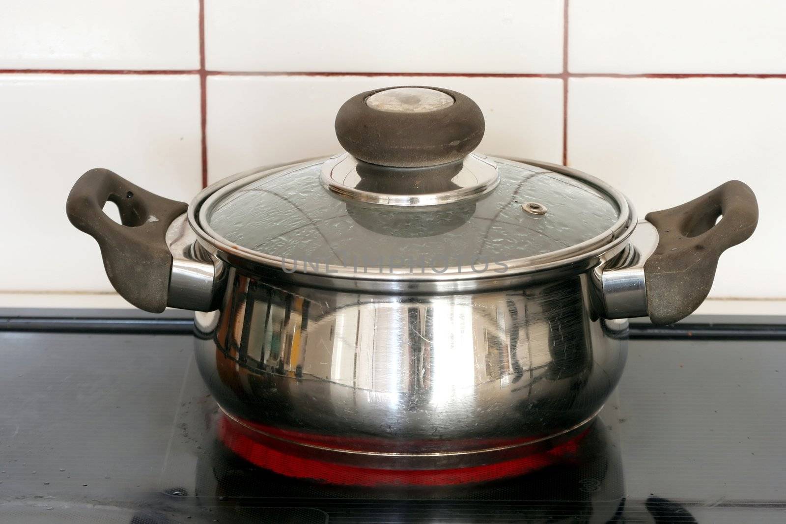 Stainless steel pot on a hot plate of a stove