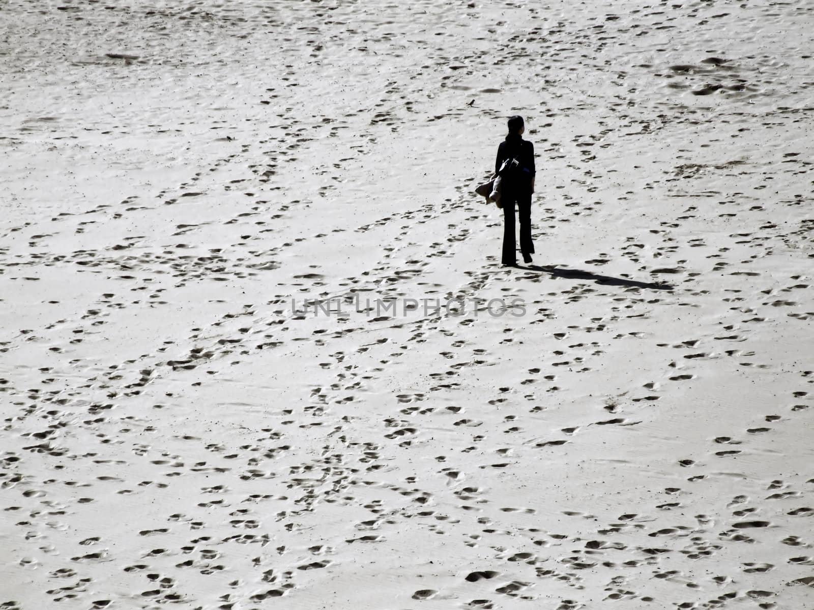 Lone woman lost amidst various tracks and directions in sand