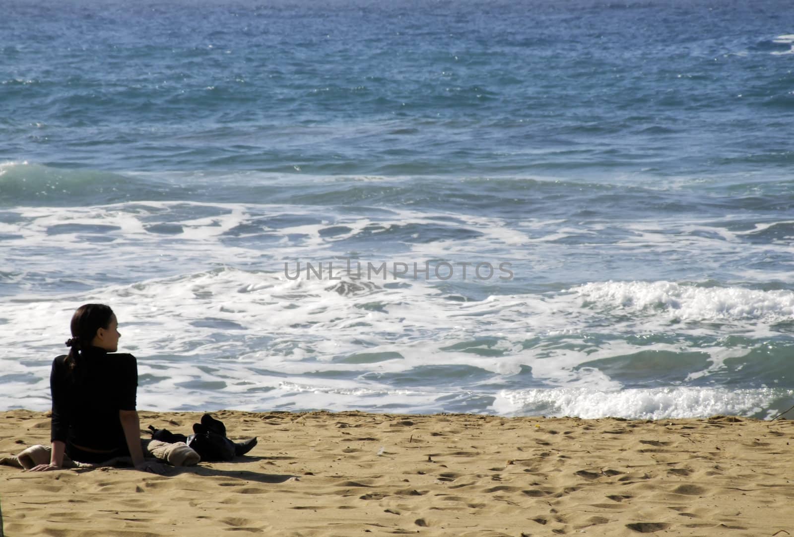 Young woman watching glistening waves of the ocean